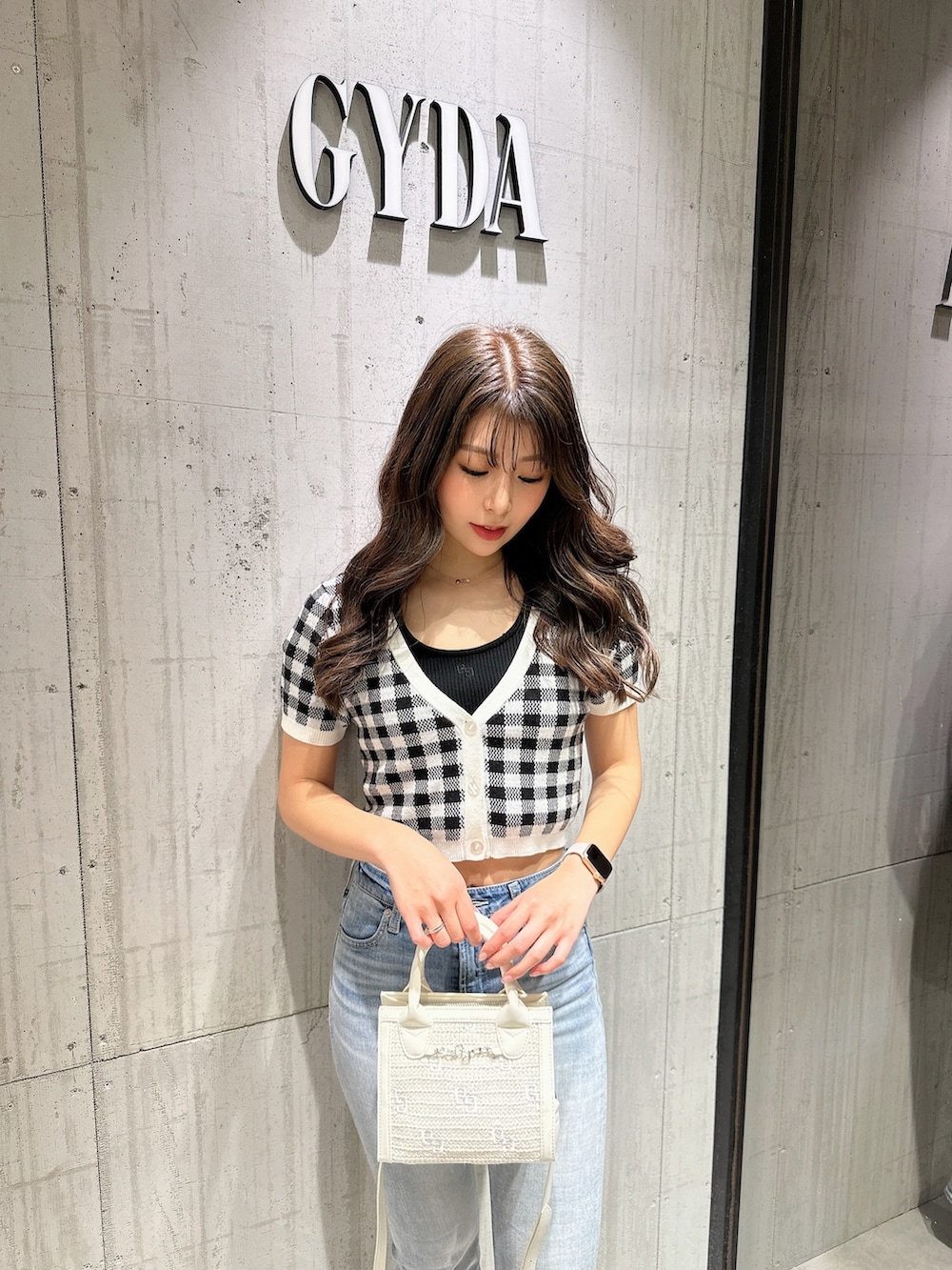 ブラック系のTシャツ/カットソー、ブラック系のカーディガン/ボレロ、ブルー系のデニムパンツを着用したレディースの春コーディネートの4枚目の写真