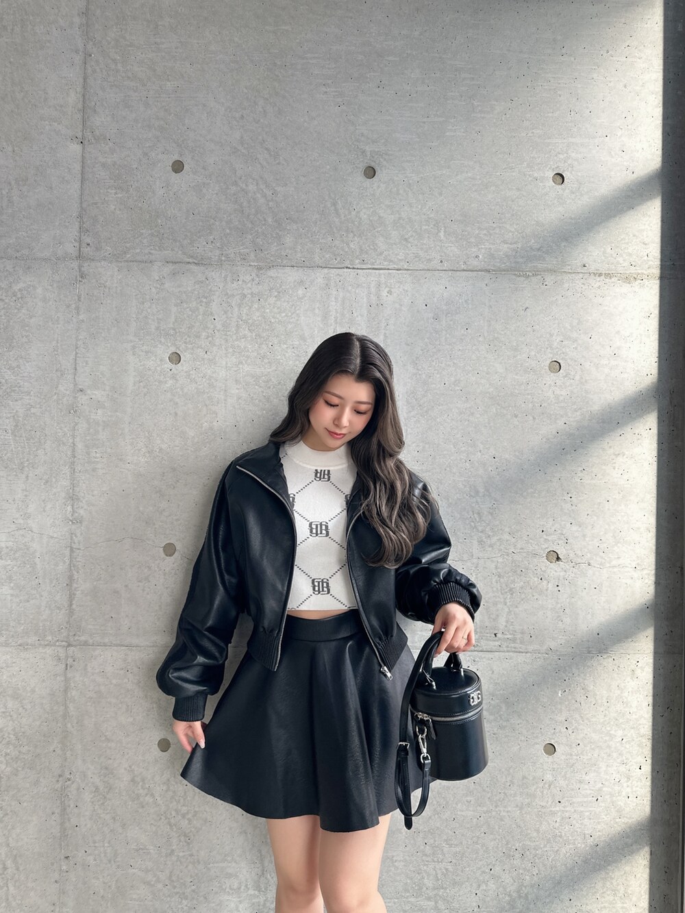 ブラック系のブーツ、ブラック系のスカート、ブラック系のブルゾンを着用したレディースの冬コーディネートの3枚目の写真