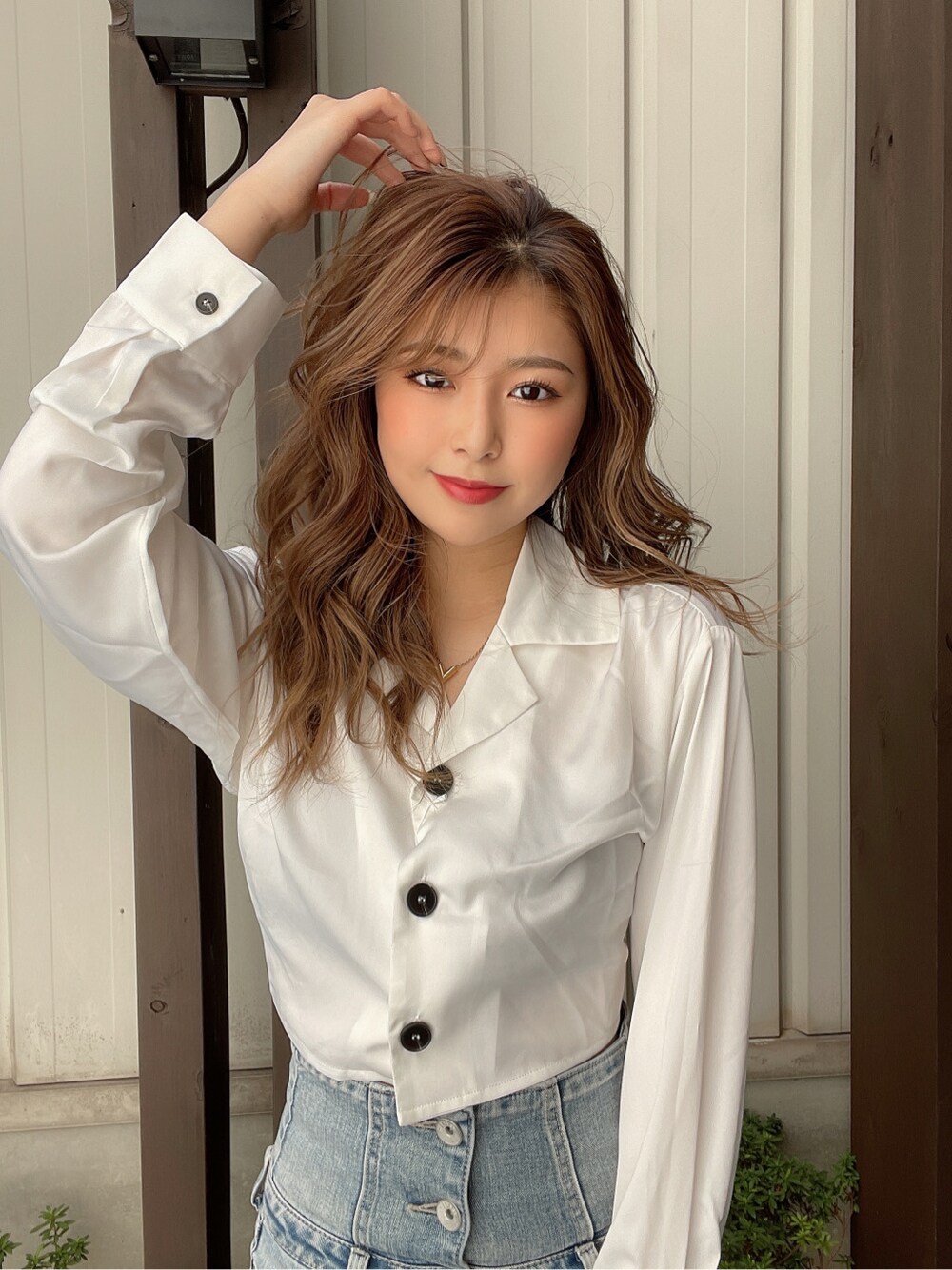 ブルー系のデニムパンツ、ブラック系のチューブトップ、ホワイト系のパンプスを着用したレディースの春コーディネートの3枚目の写真