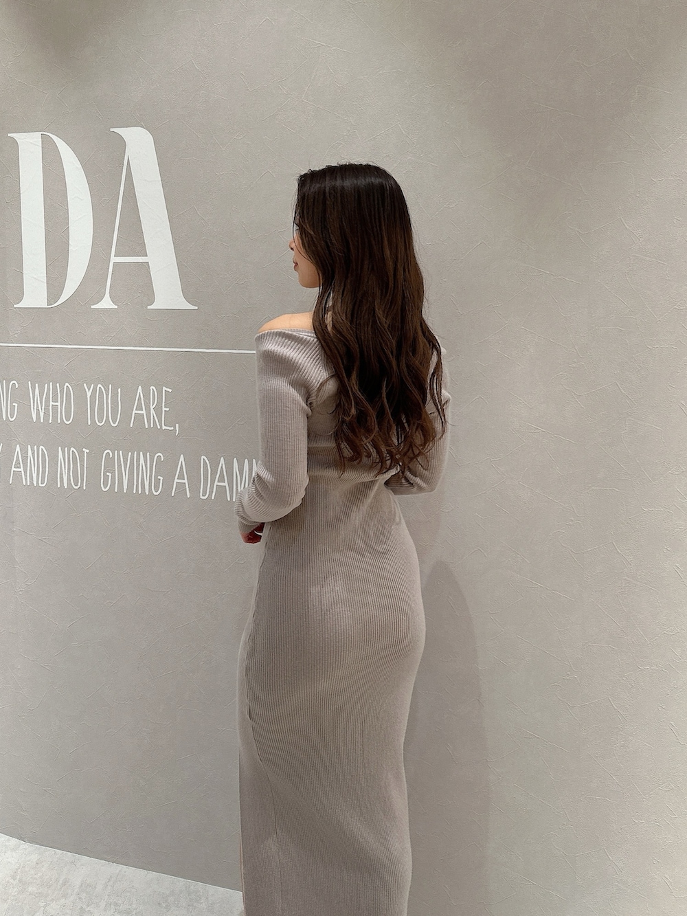 グレー系のワンピース、ホワイト系のブルゾン、ブラック系のハンドバッグを着用したレディースの春コーディネートの7枚目の写真