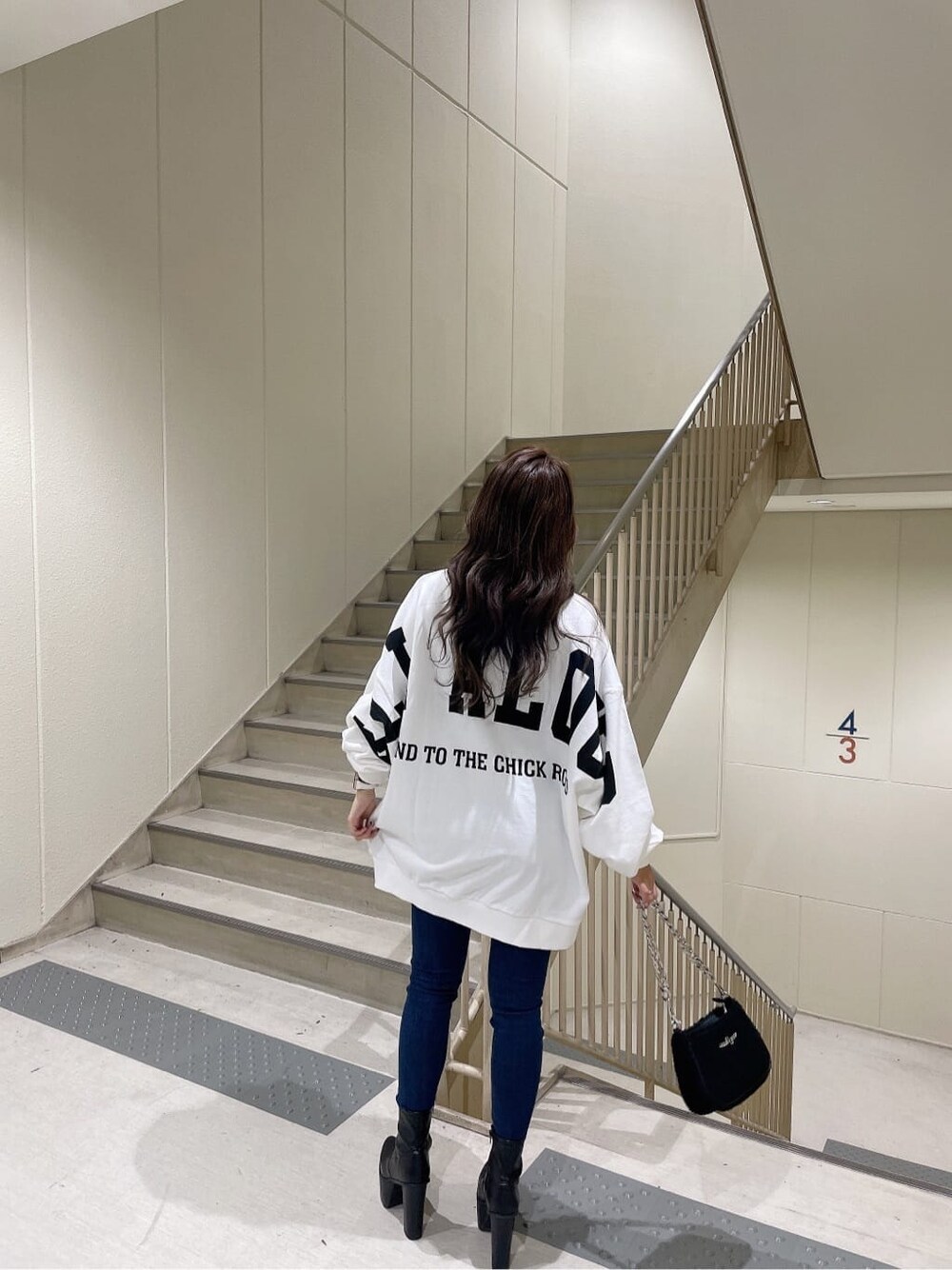 ブルー系のデニムパンツ、ブルー系のデニムパンツ、ブラック系のブーツを着用したレディースの秋コーディネートの3枚目の写真