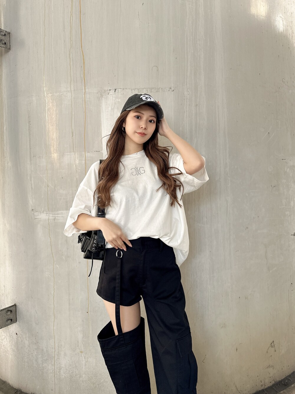 ブラック系のその他パンツ、ホワイト系のTシャツ/カットソー、ブラック系のハンドバッグを着用したレディースの春コーディネートの3枚目の写真