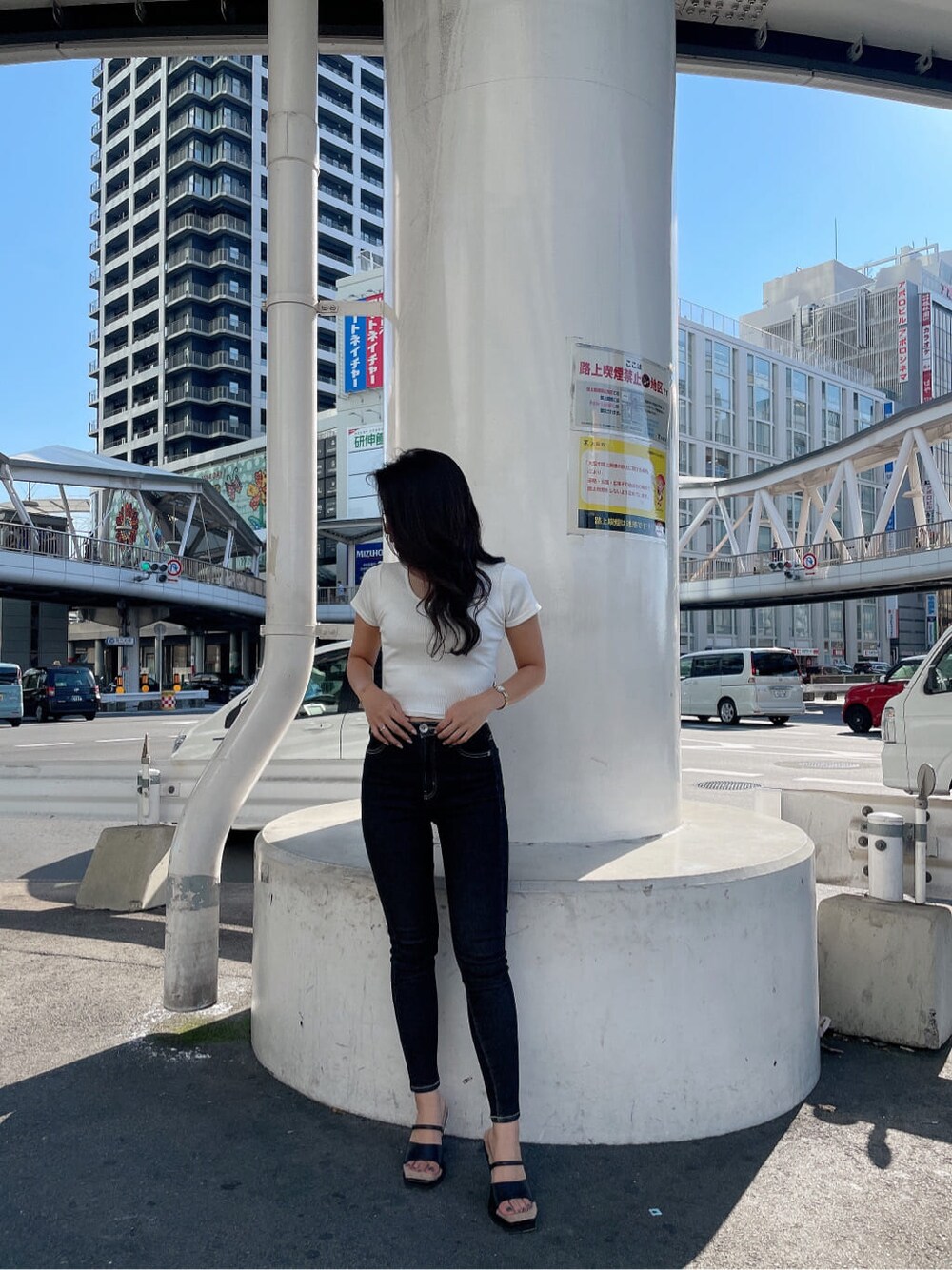 ブラック系のサンダル、ホワイト系のTシャツ/カットソー、ブラック系のデニムパンツを着用したレディースの夏コーディネートの3枚目の写真