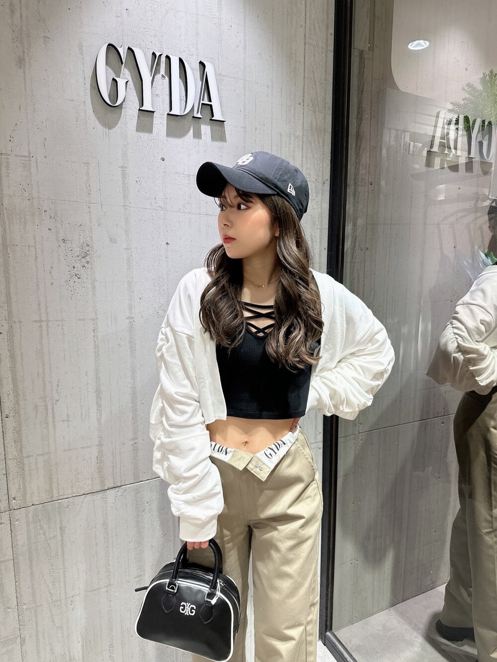 ブラック系のTシャツ/カットソー、ホワイト系のカーディガン/ボレロ、ベージュ系のその他パンツを着用したレディースの春コーディネートの7枚目の写真