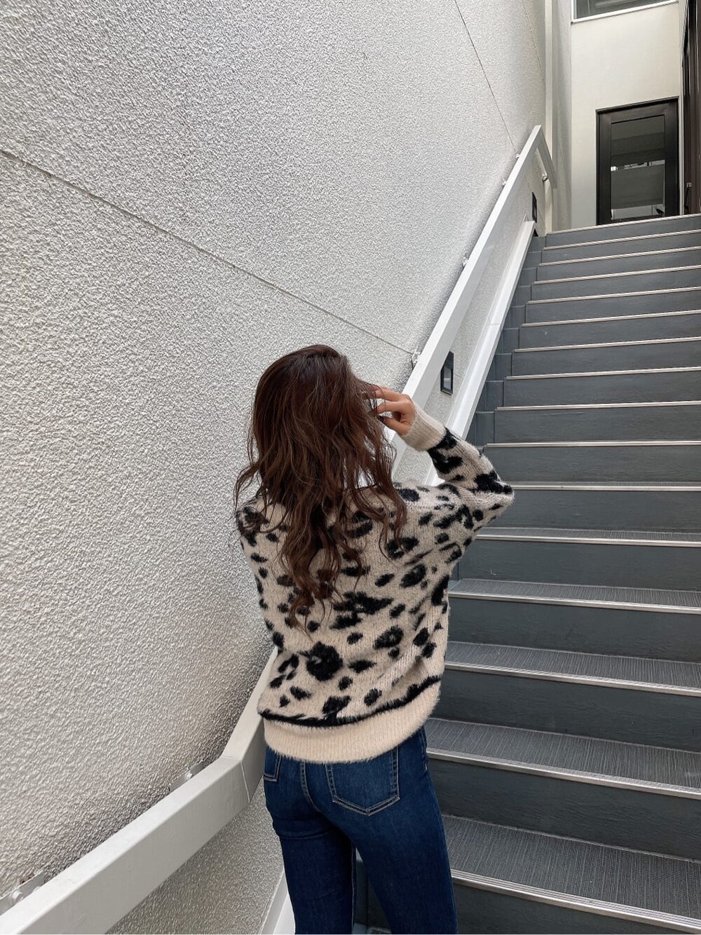 ホワイト系のニット/セーター、ブルー系のデニムパンツ、ブラック系のブーツを着用したレディースの秋コーディネートの8枚目の写真