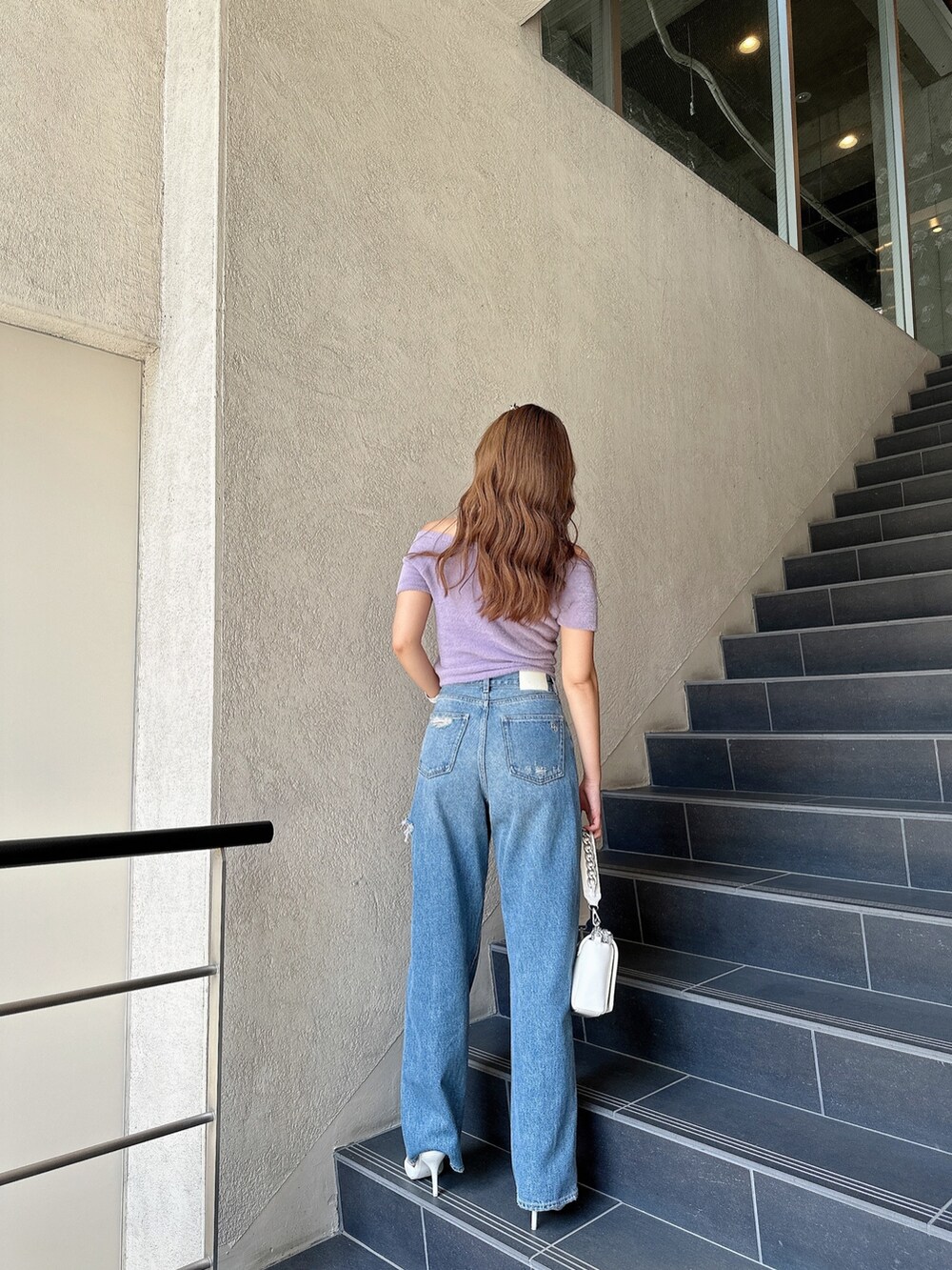 ブラック系のパンプス、パープル系のニット/セーター、ホワイト系のハンドバッグを着用したレディースの夏コーディネートの4枚目の写真