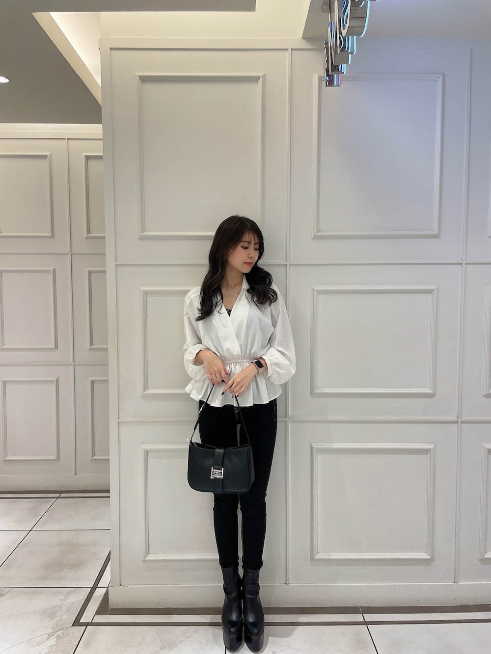 ホワイト系のシャツ/ブラウス、ブラック系のデニムパンツ、ホワイト系のハンドバッグを着用したレディースの冬コーディネートの2枚目の写真