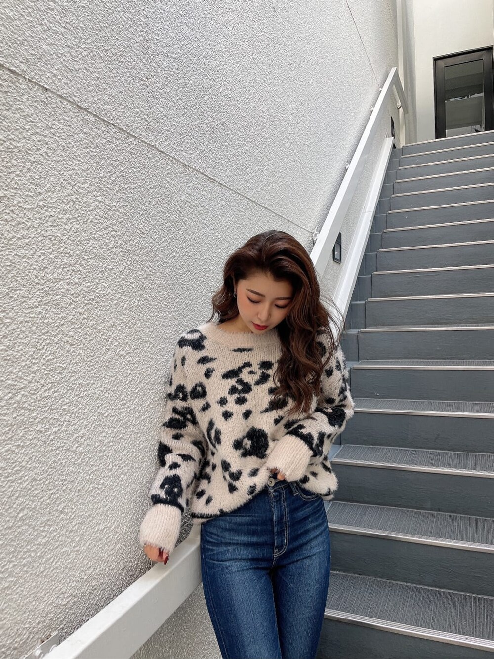 ホワイト系のニット/セーター、ブルー系のデニムパンツ、ブラック系のブーツを着用したレディースの秋コーディネートの7枚目の写真