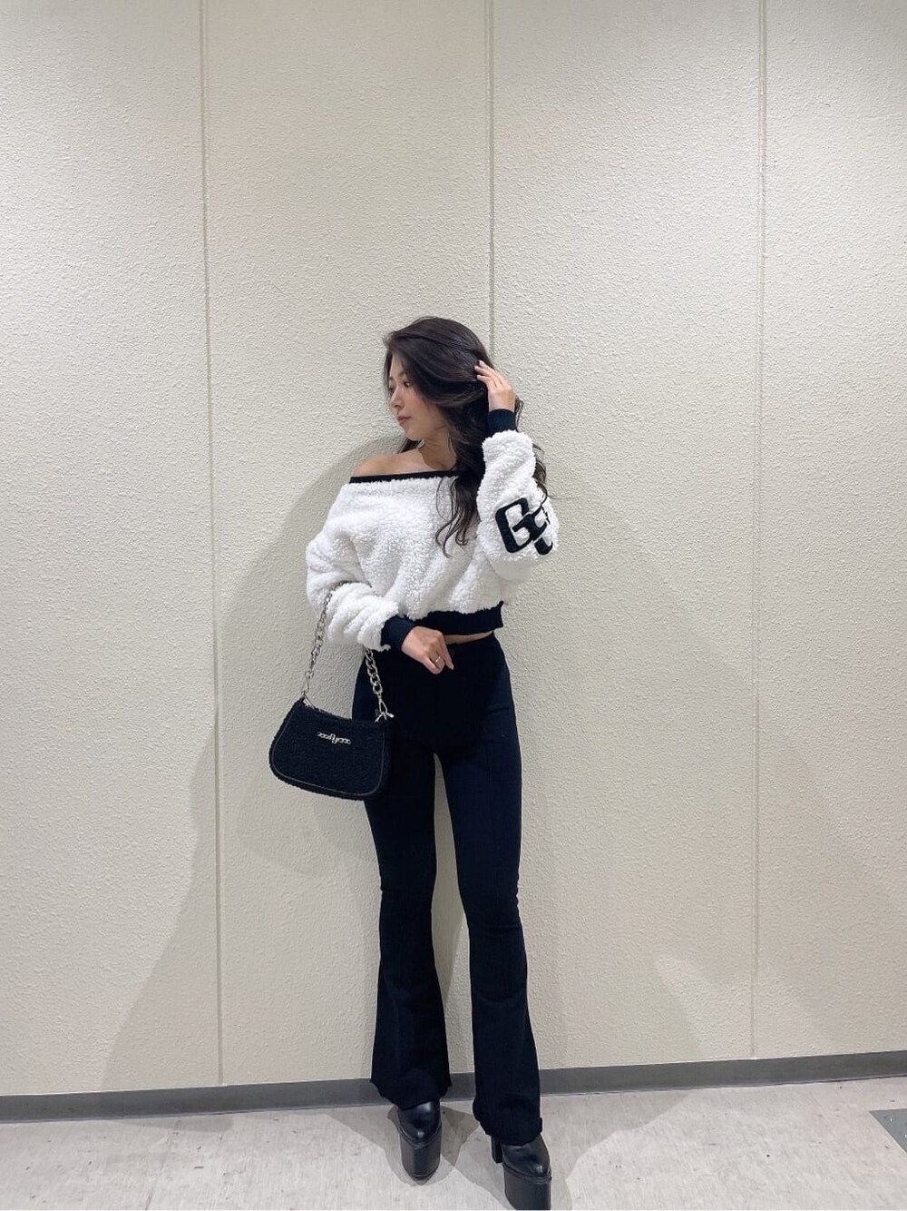 ブラック系のブーツ、ホワイト系のTシャツ/カットソー、ブラック系のスウェットパンツを着用したレディースの秋コーディネートの2枚目の写真