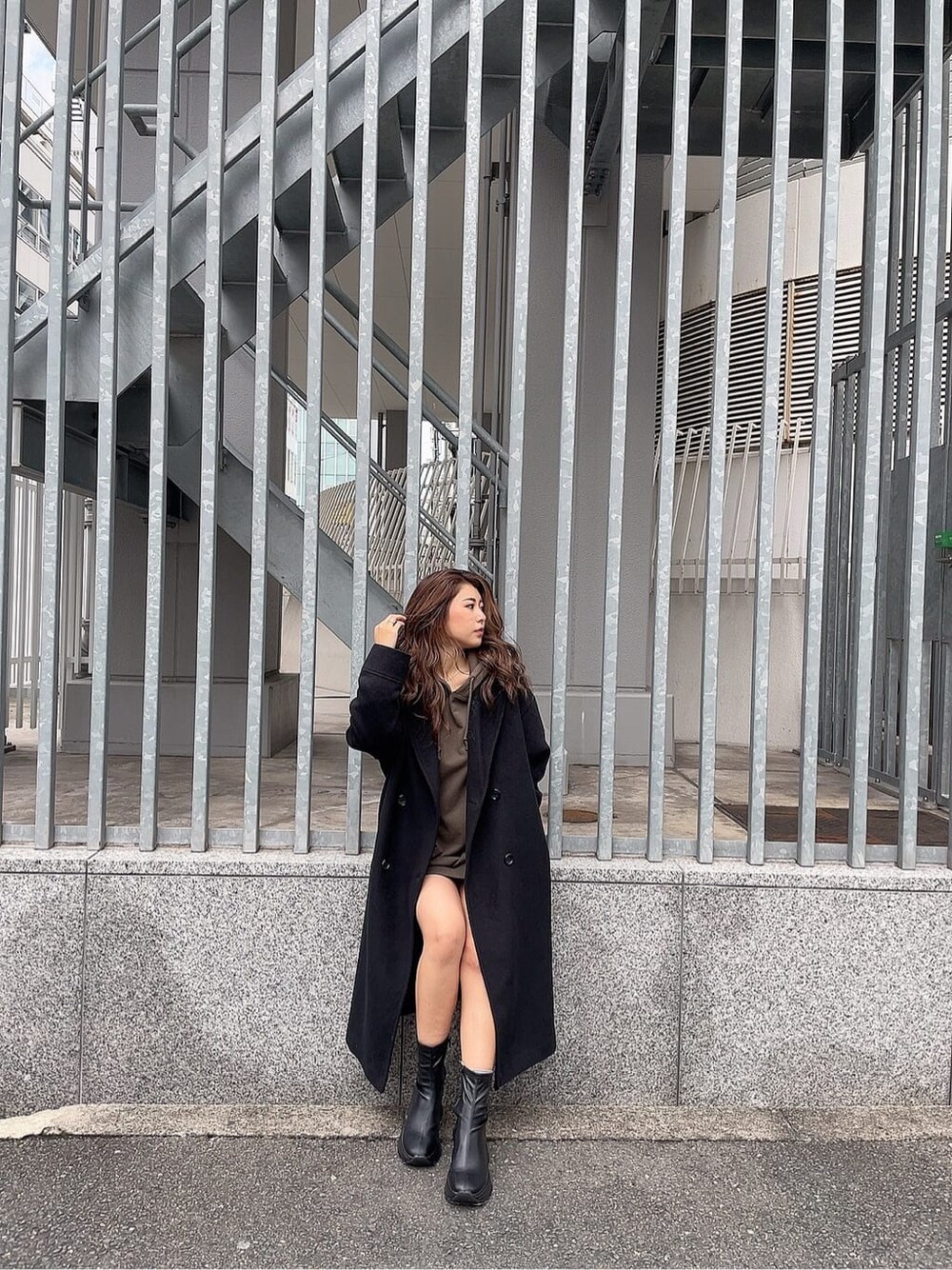 ブラック系のブーツ、ベージュ系のパーカー、ブラック系のチェスターコートを着用したレディースの秋コーディネートの4枚目の写真