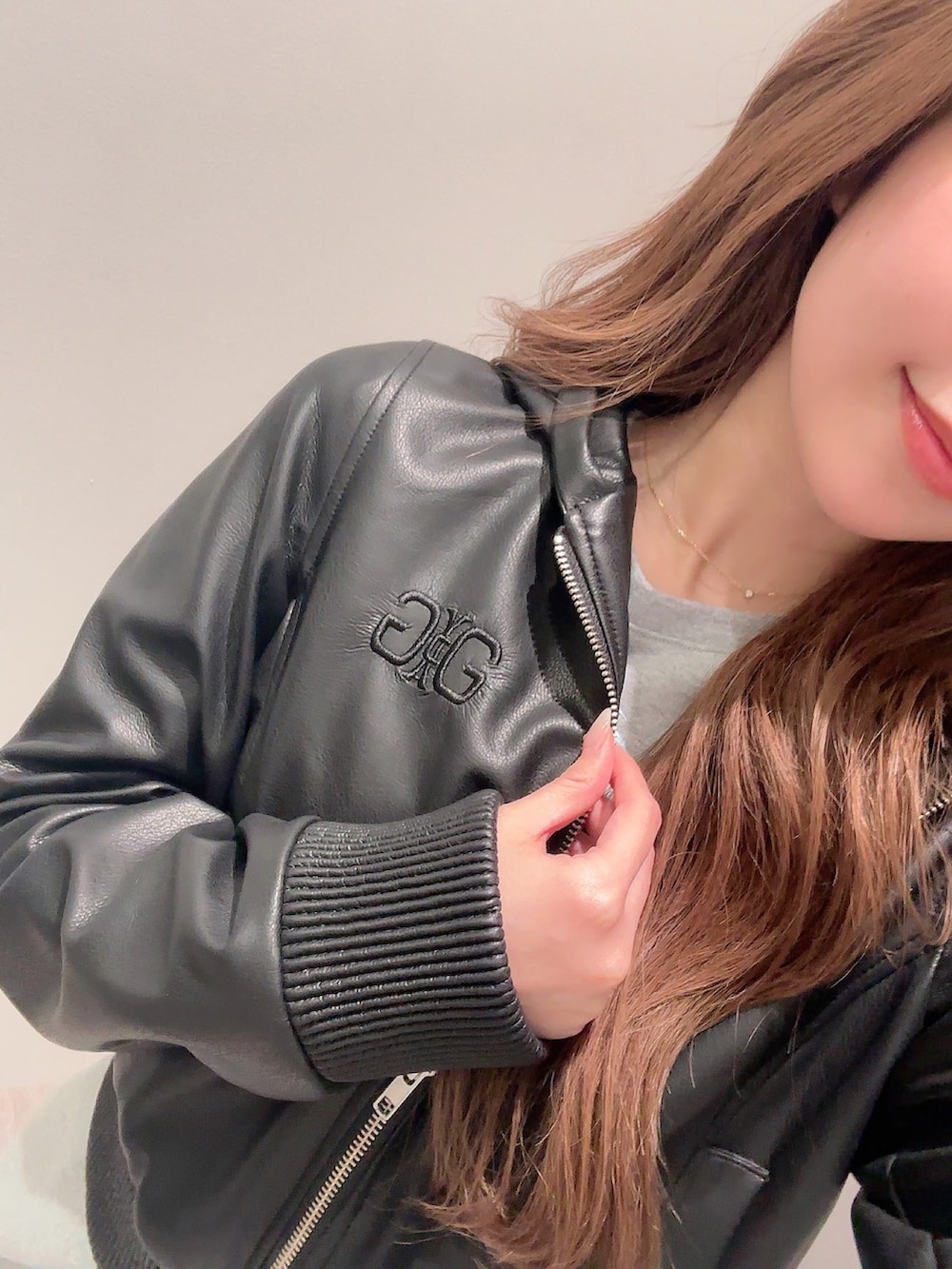 ブラック系のブルゾン、グレー系のワンピースを着用したレディースの春コーディネートの5枚目の写真