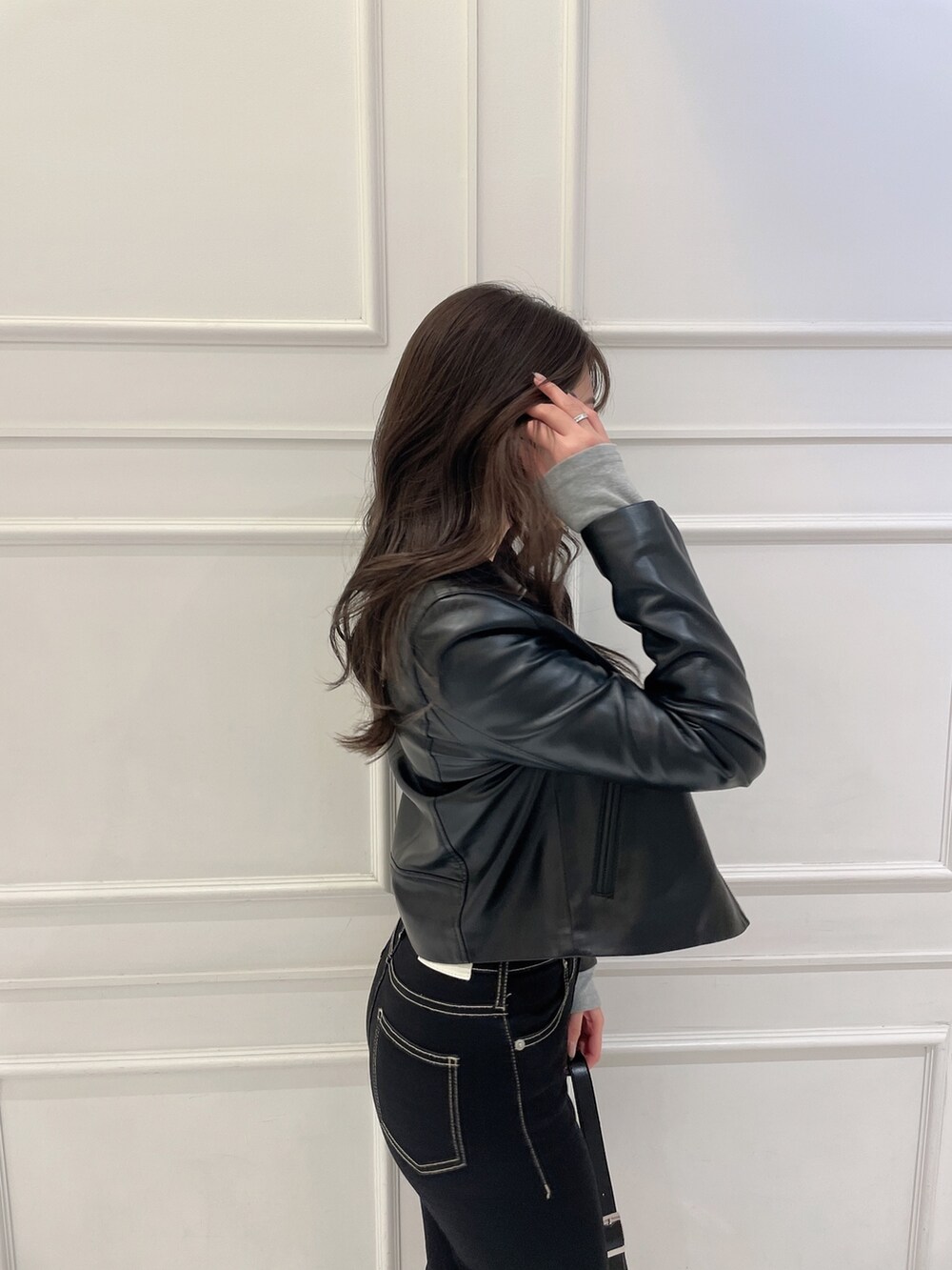 グレー系のTシャツ/カットソー、ブラック系のライダースジャケット、ブラック系のハンドバッグを着用したレディースの冬コーディネートの4枚目の写真