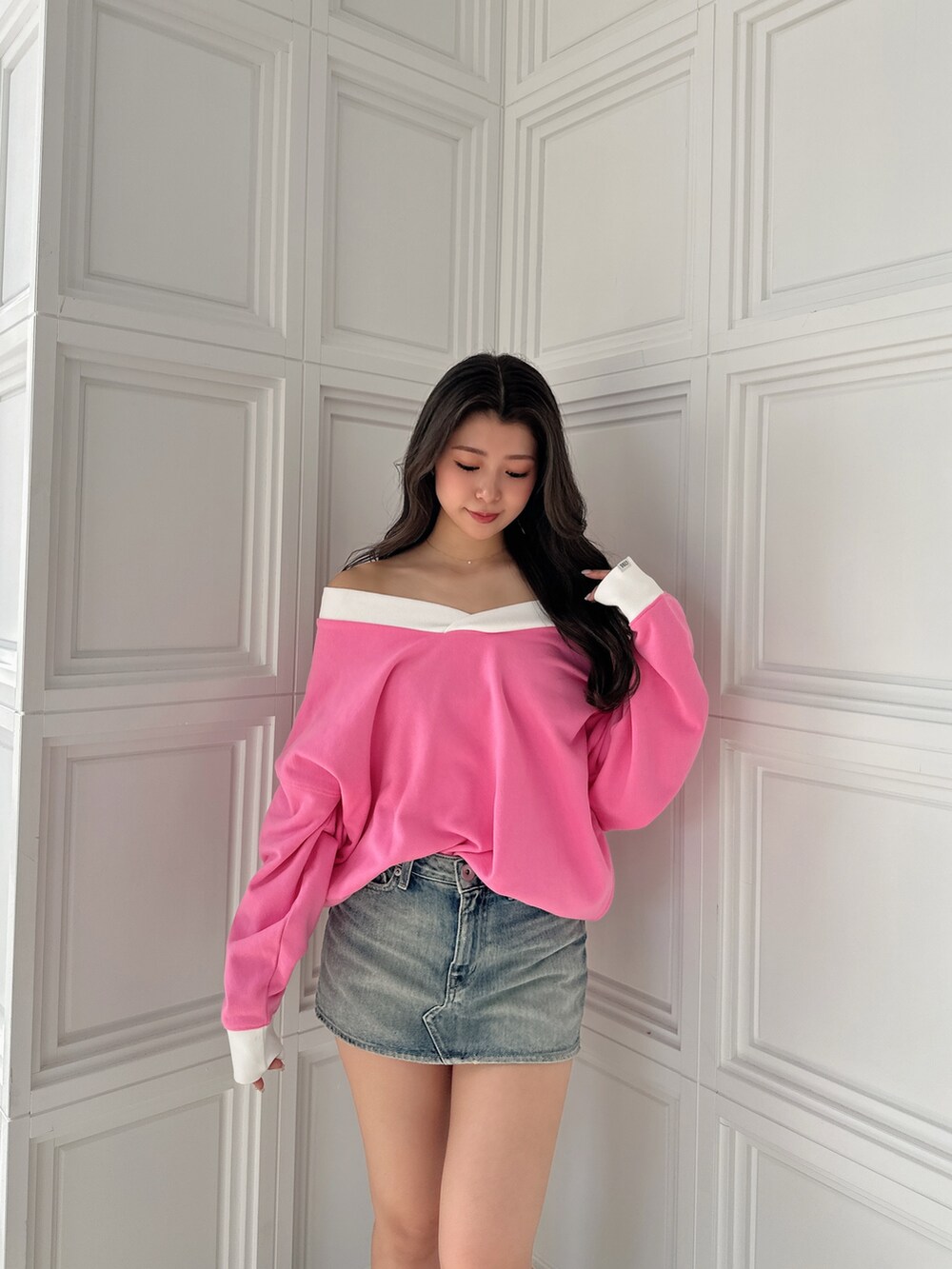 ブラック系のブーツ、ブルー系のデニムスカート、ピンク系のスウェットを着用したレディースの冬コーディネートの4枚目の写真