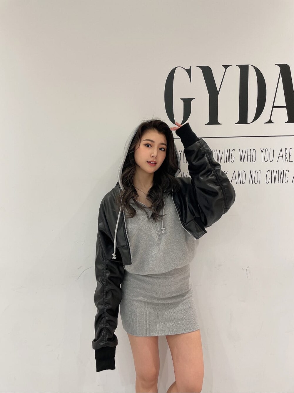 ブラック系のブーツ、グレー系のワンピース、ブラック系のブルゾンを着用したレディースの冬コーディネートの5枚目の写真