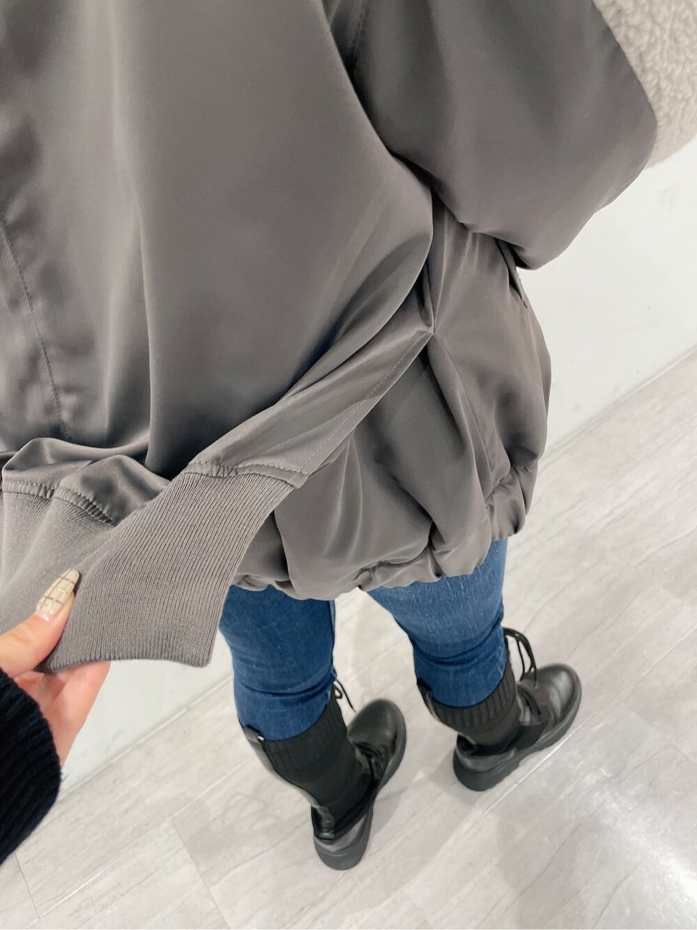 ブラック系のバックパック/リュック、ブラック系のブーツ、ブルー系のデニムパンツを着用したレディースの秋コーディネートの8枚目の写真