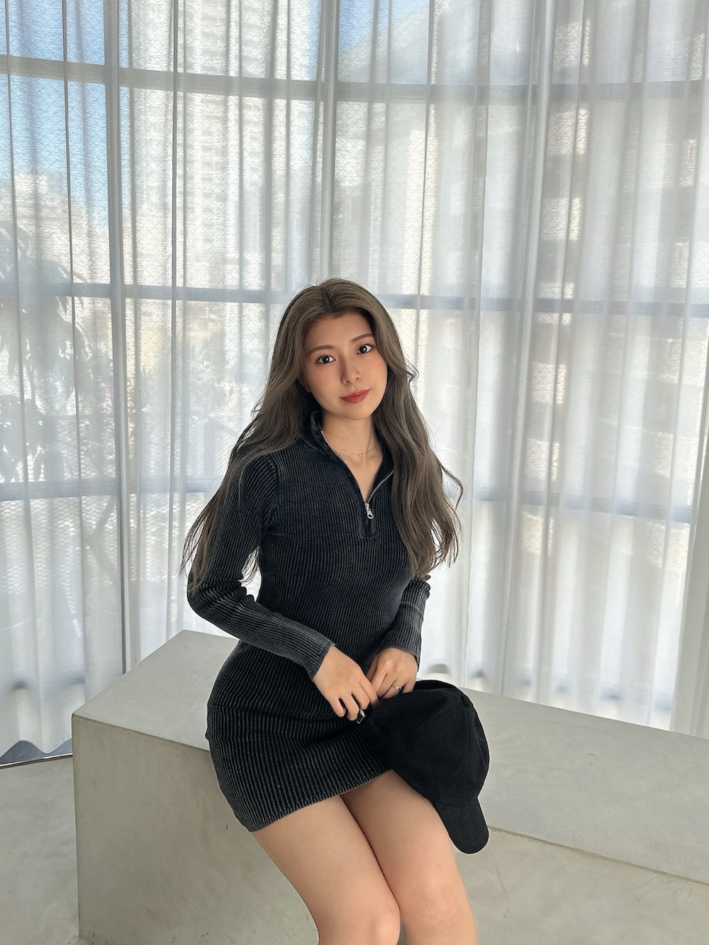 ブラック系のワンピース、ブラック系のブーツ、ブラック系のキャップを着用したレディースの秋コーディネートの3枚目の写真