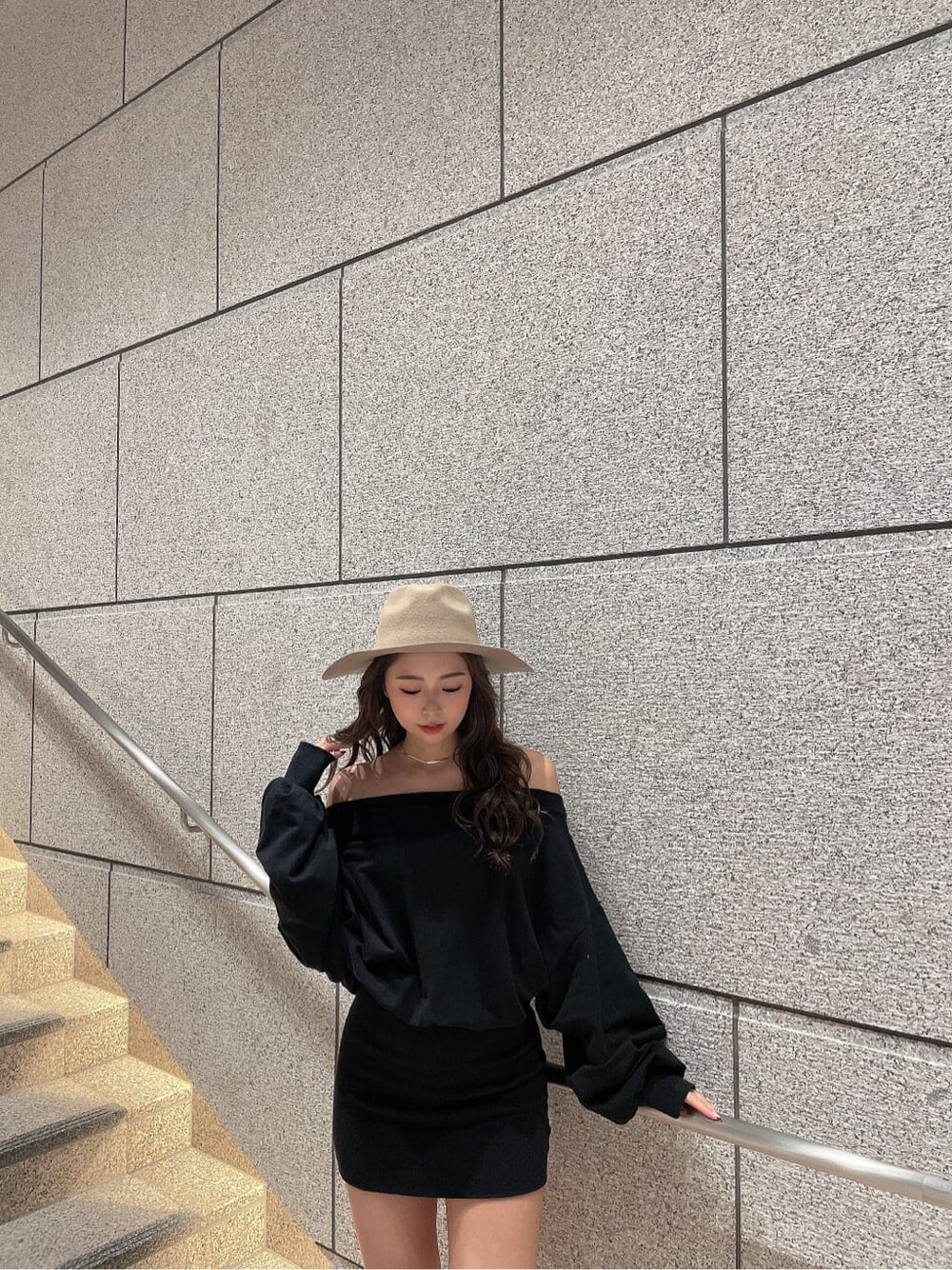 ブラック系のワンピース、ブラック系のブーツ、ベージュ系のハットを着用したレディースの秋コーディネートの5枚目の写真