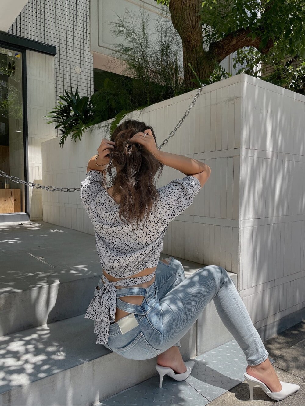 ホワイト系のシャツ/ブラウス、ホワイト系のパンプス、ブルー系のデニムパンツを着用したレディースの夏コーディネートの4枚目の写真