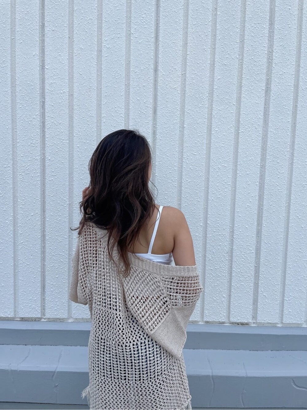 ホワイト系のサンダル、ブルー系のデニムパンツ、ホワイト系のハンドバッグを着用したレディースの夏コーディネートの5枚目の写真