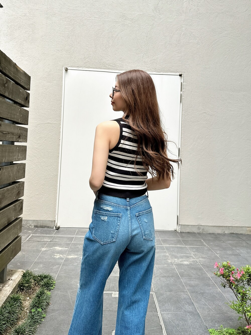 ブルー系のデニムパンツ、ホワイト系のパンプス、ホワイト系のニット/セーターを着用したレディースの夏コーディネートの4枚目の写真