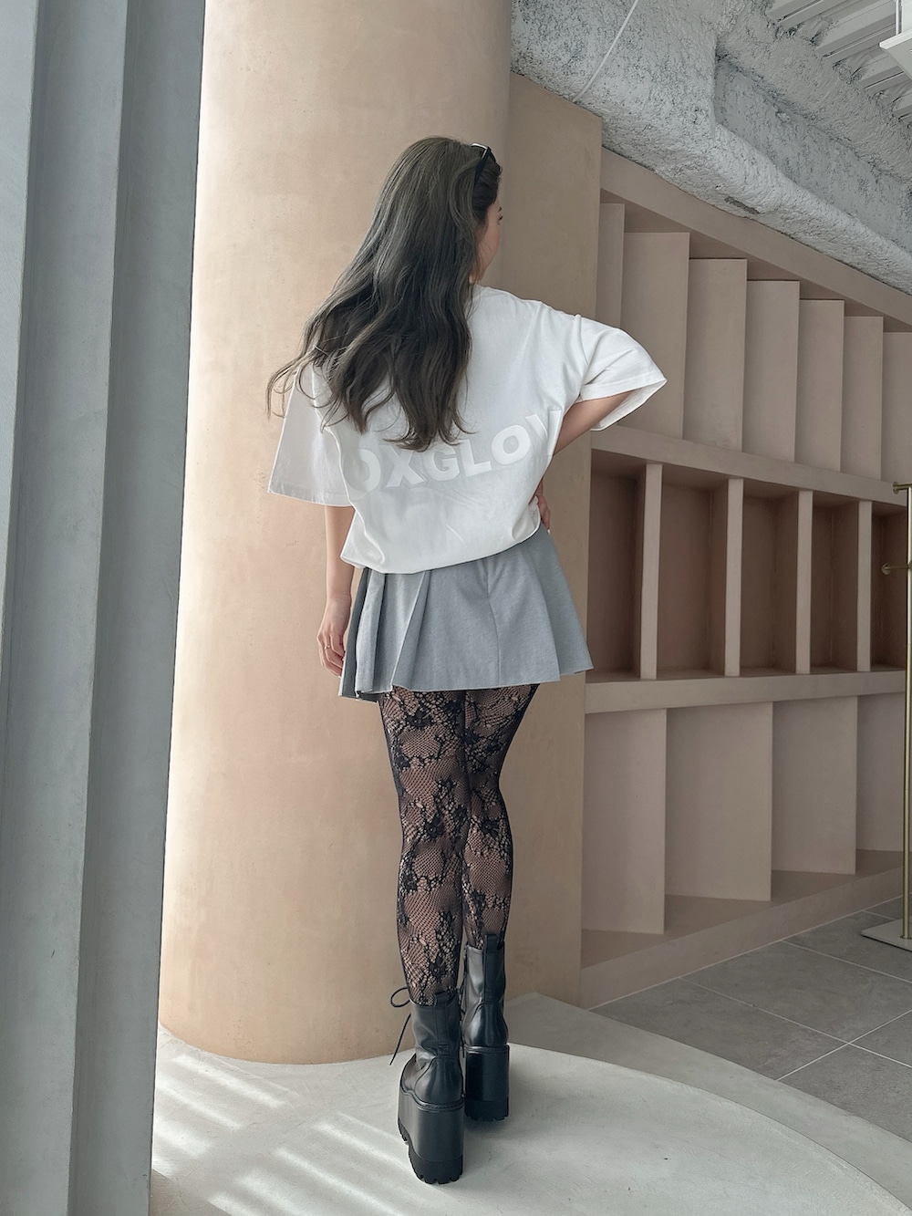 ホワイト系のTシャツ/カットソー、グレー系のスカート、ブラック系のブーツを着用したレディースの夏コーディネートの2枚目の写真