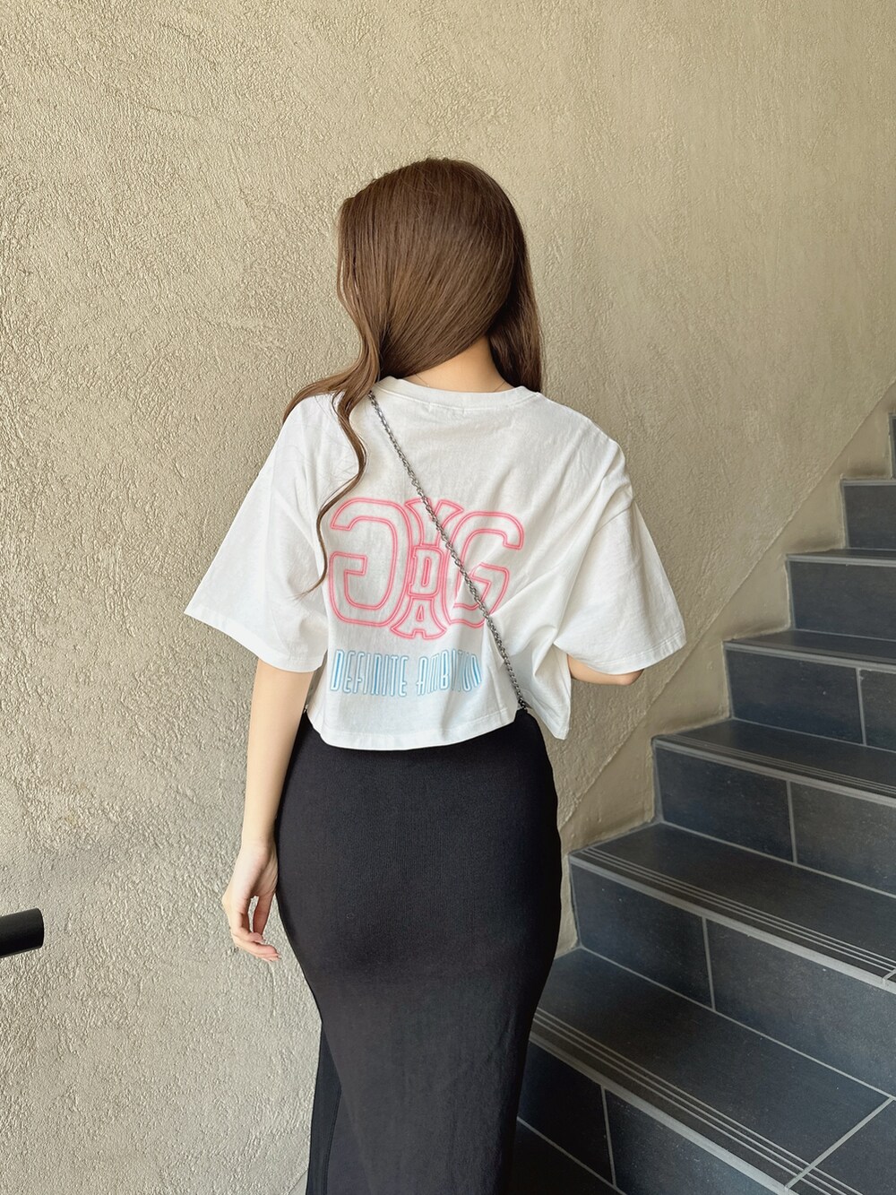 ブラック系のスカート、ホワイト系のTシャツ/カットソーを着用したレディースの春コーディネートの4枚目の写真