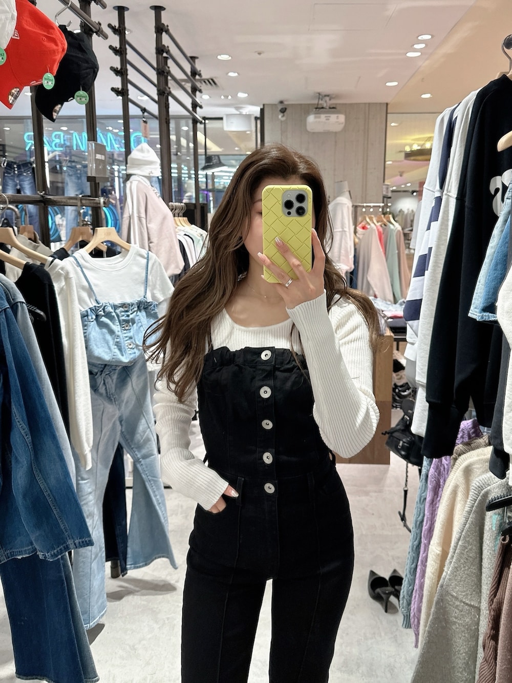 ブラック系のサロペット/オーバーオール、ホワイト系のニット/セーター、ブラック系のパンプスを着用したレディースの春コーディネートの4枚目の写真