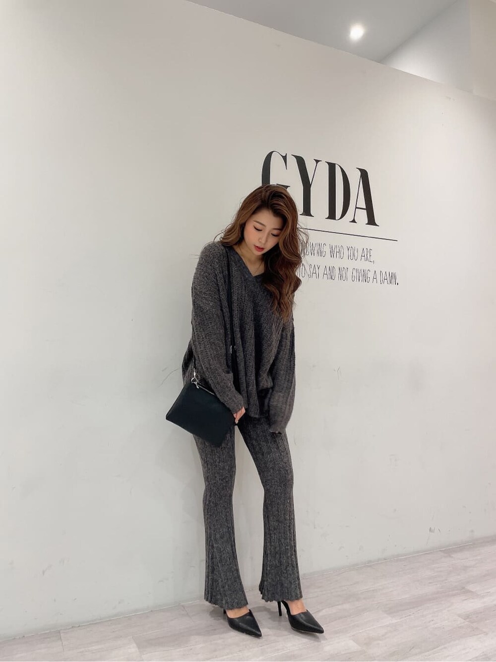 ブラック系のパンプス、グレー系のその他パンツ、ブラック系のショルダーバッグを着用したレディースの秋コーディネートの5枚目の写真