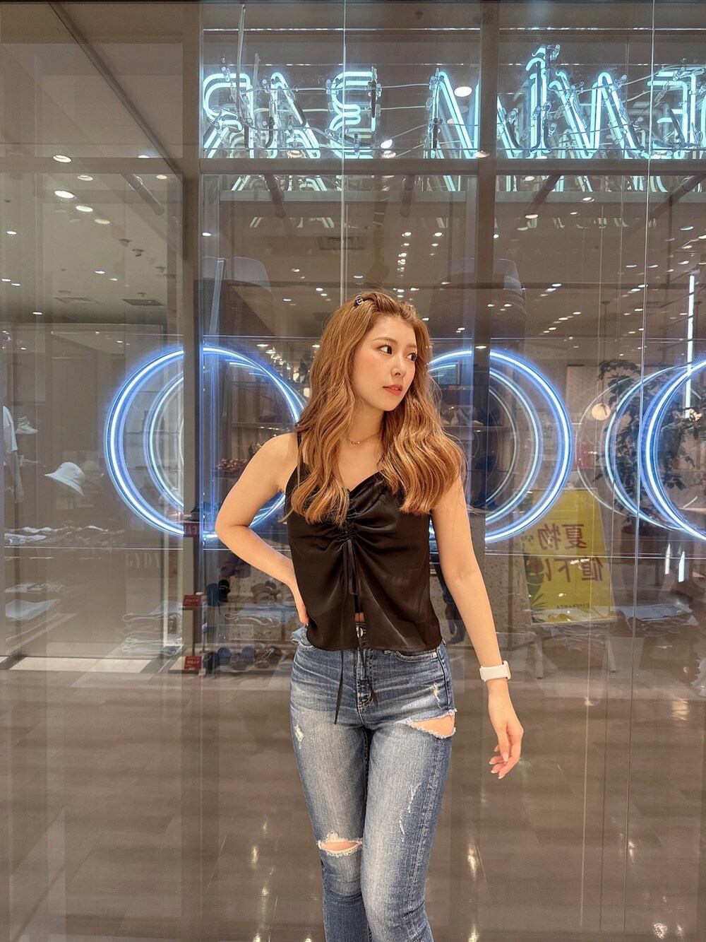 ブルー系のデニムパンツ、ブラック系のサンダル、ブラック系のキャミソールを着用したレディースの夏コーディネートの5枚目の写真