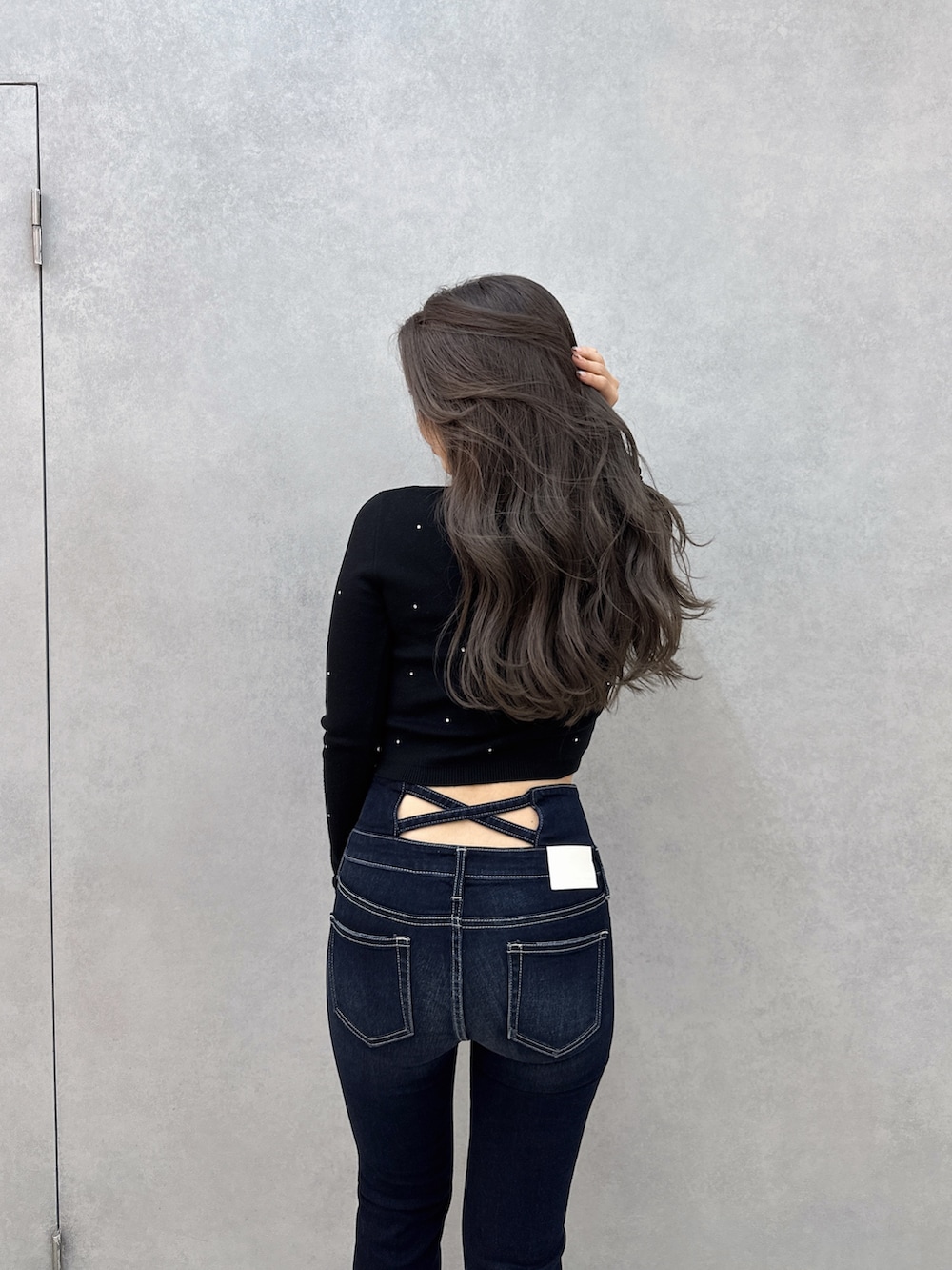 ブルー系のデニムパンツ、ブラック系のブーツ、ブラック系のニット/セーターを着用したレディースの冬コーディネートの3枚目の写真