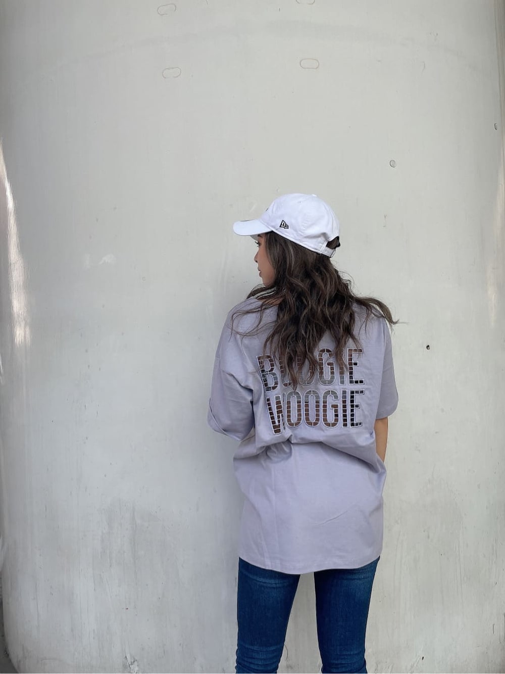 ブルー系のデニムパンツ、ホワイト系のサンダル、パープル系のTシャツ/カットソーを着用したレディースの夏コーディネートの5枚目の写真