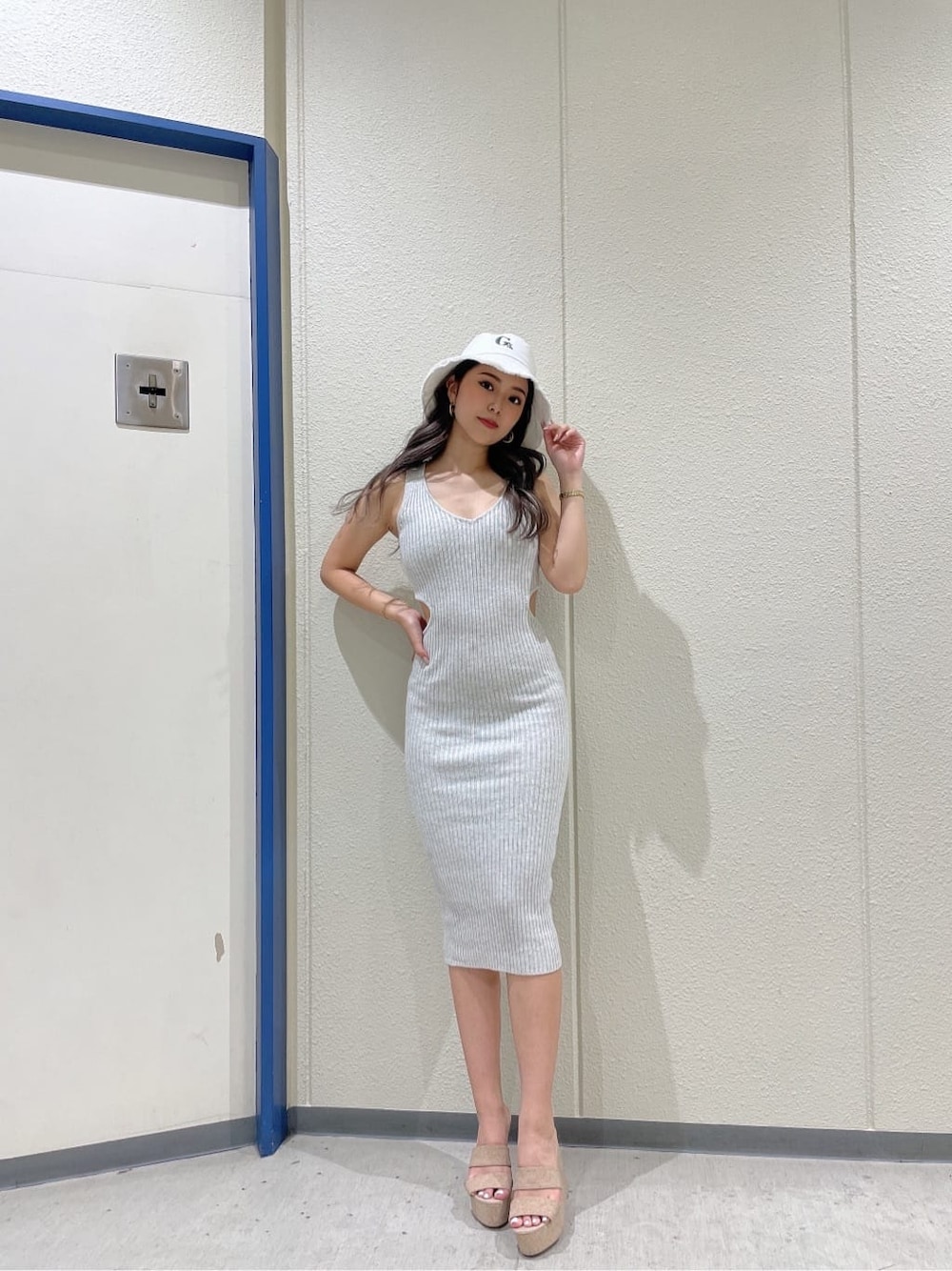 ホワイト系のサンダル、グレー系のワンピース、ホワイト系のハットを着用したレディースの夏コーディネートの2枚目の写真