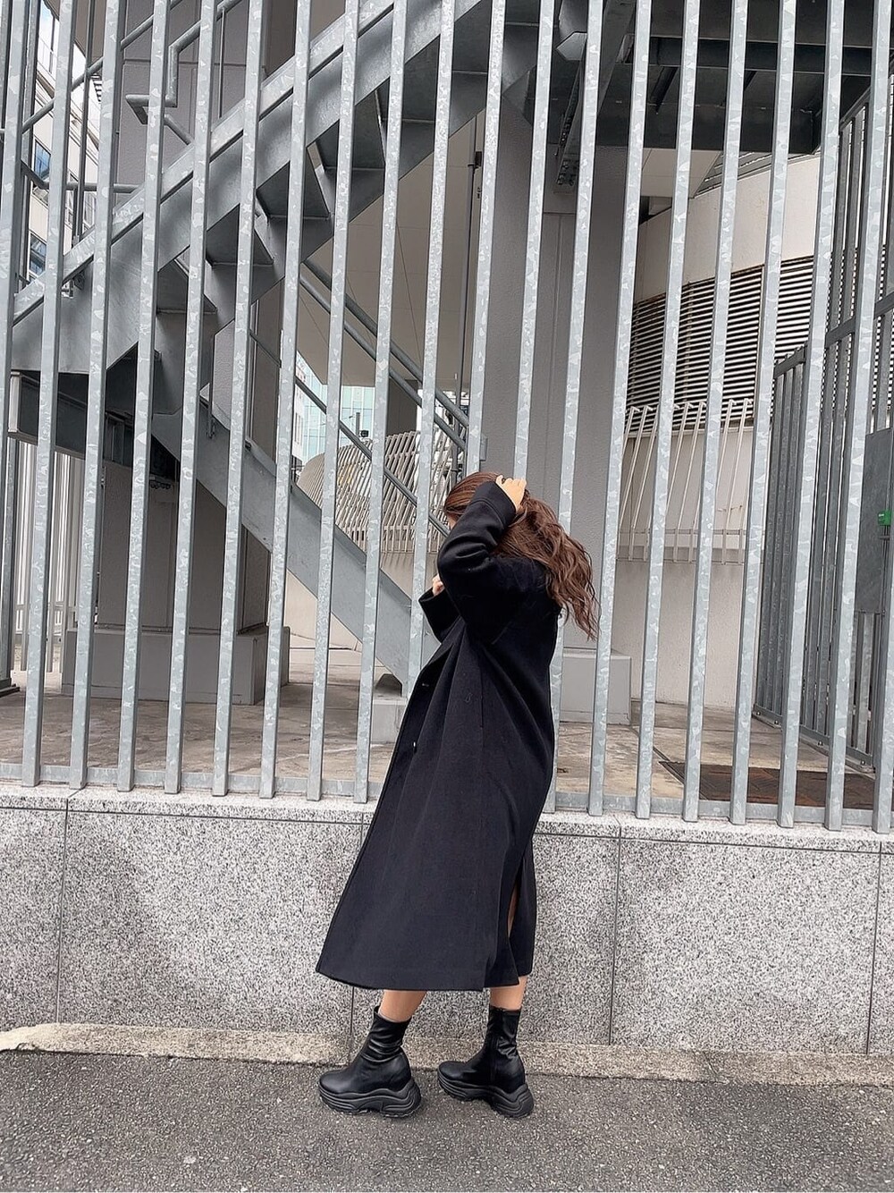 ブラック系のブーツ、ベージュ系のパーカー、ブラック系のチェスターコートを着用したレディースの秋コーディネートの3枚目の写真