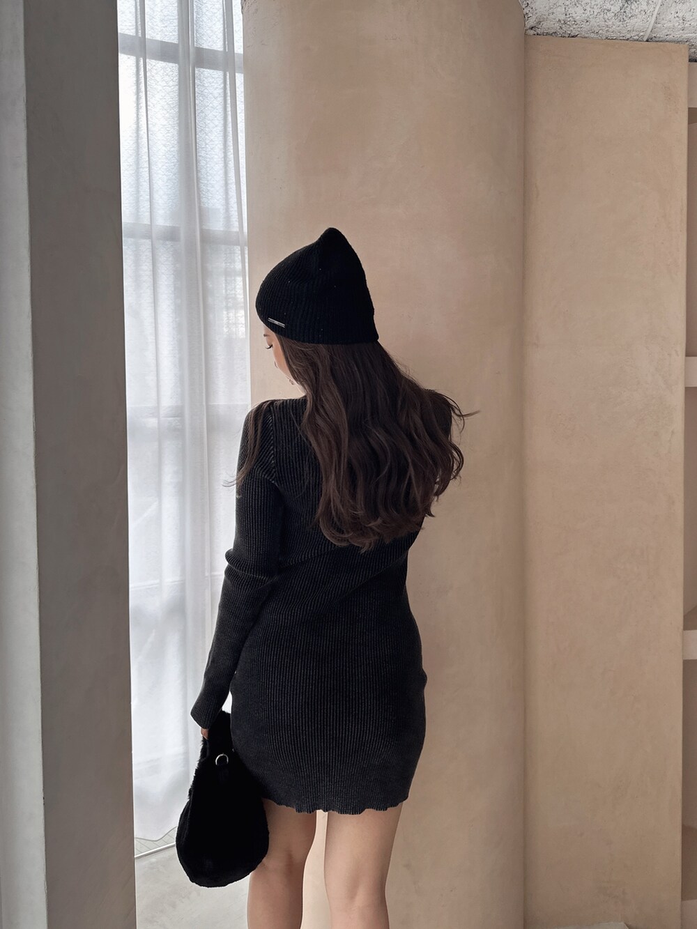 ブラック系のワンピース、ブラック系のブーツ、ブラック系のニットキャップ/ビーニーを着用したレディースの冬コーディネートの8枚目の写真