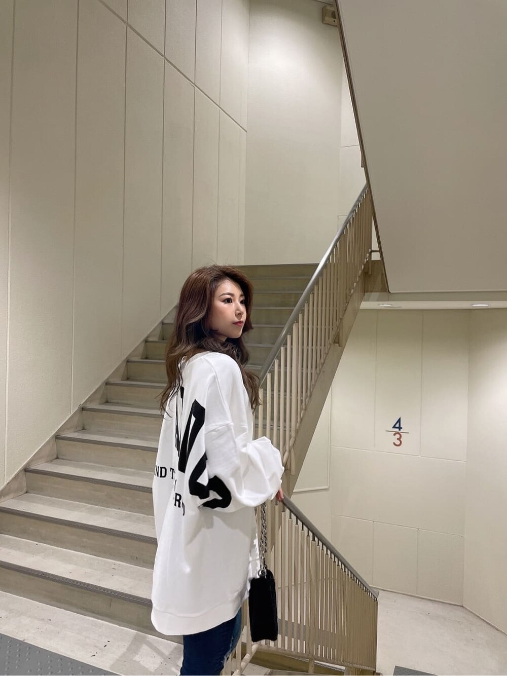ブルー系のデニムパンツ、ブルー系のデニムパンツ、ブラック系のブーツを着用したレディースの秋コーディネートの5枚目の写真