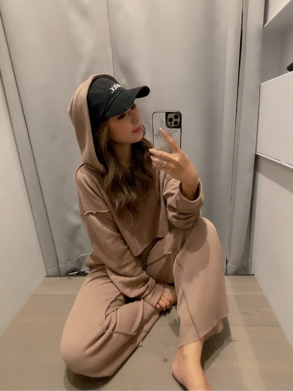 ベージュ系のその他パンツ、ベージュ系のパーカー、ブラック系のキャップを着用したレディースの夏コーディネートの3枚目の写真