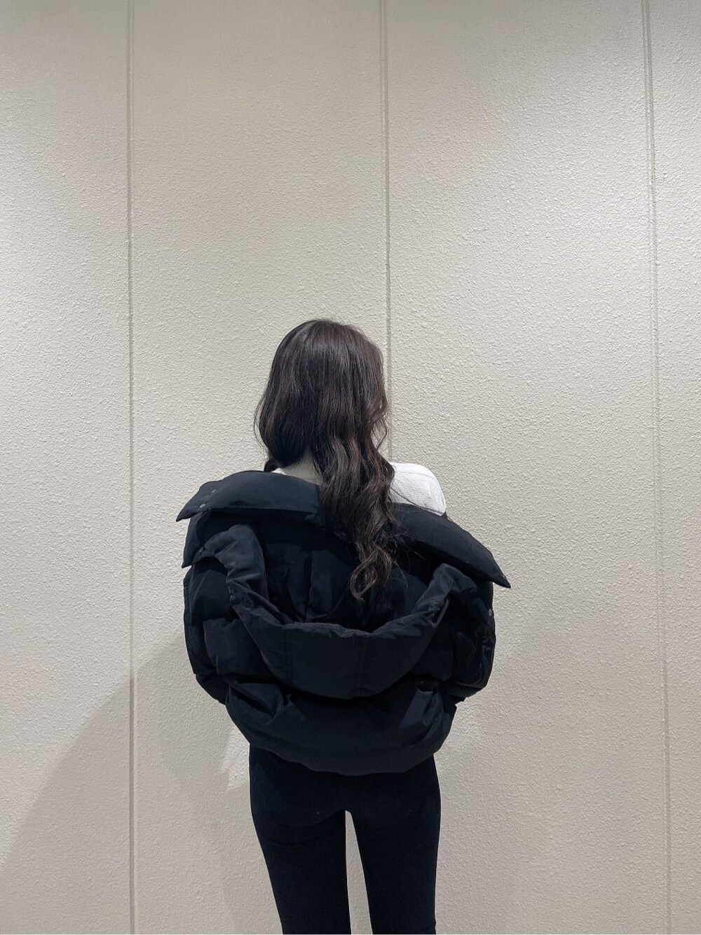 ブラック系のブーツ、ブラック系のダウンジャケット/コート、ホワイト系のニット/セーターを着用したレディースの秋コーディネートの6枚目の写真