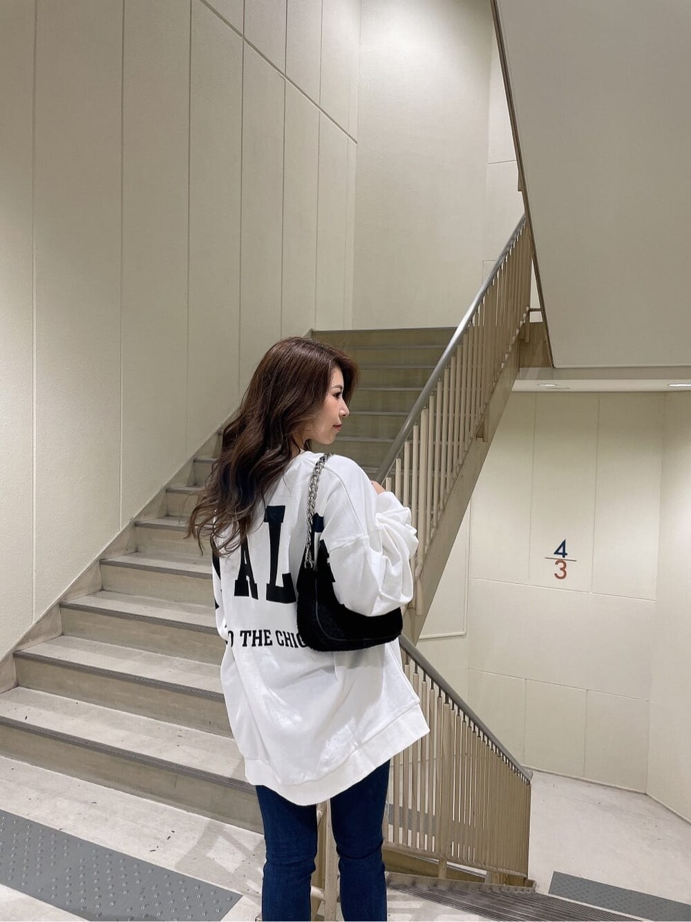 ブルー系のデニムパンツ、ブルー系のデニムパンツ、ブラック系のブーツを着用したレディースの秋コーディネートの6枚目の写真