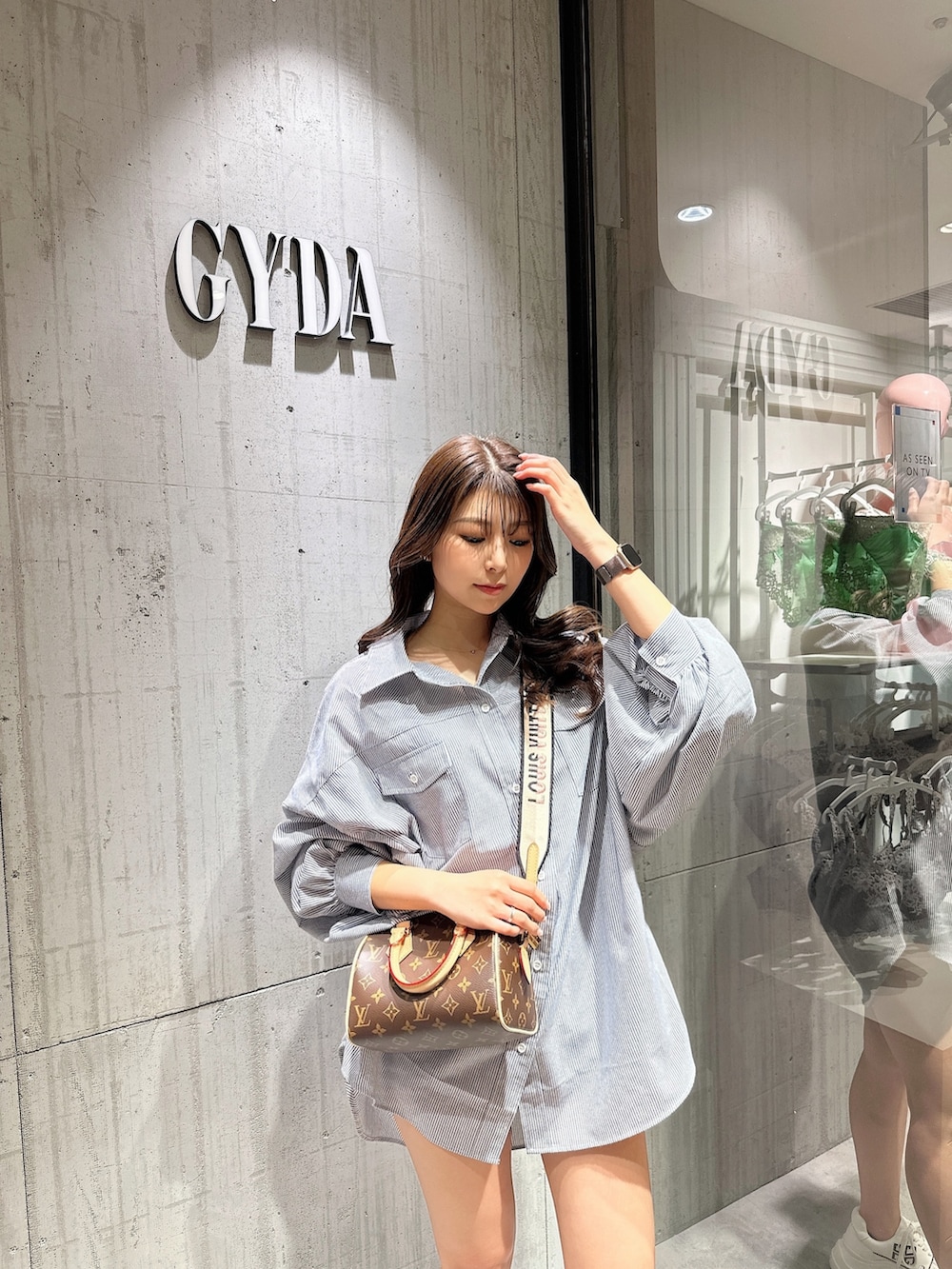 ブルー系のシャツ/ブラウス、ブラック系のスニーカーを着用したレディースの春コーディネートの3枚目の写真