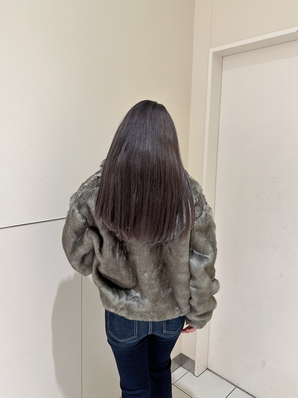 ブルー系のデニムパンツ、ホワイト系のニット/セーター、ブラック系のブーツを着用したレディースの秋コーディネートの5枚目の写真