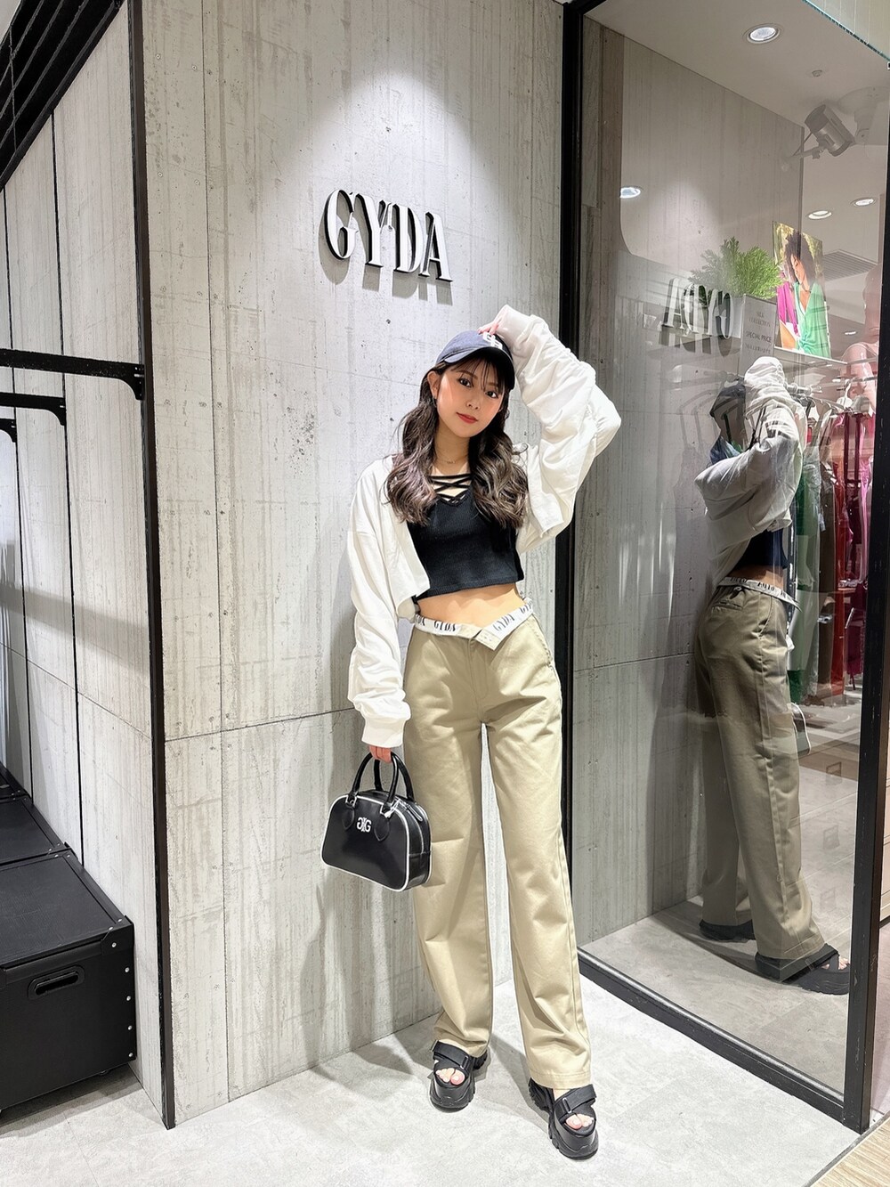 ブラック系のTシャツ/カットソー、ホワイト系のカーディガン/ボレロ、ベージュ系のその他パンツを着用したレディースの春コーディネートの2枚目の写真