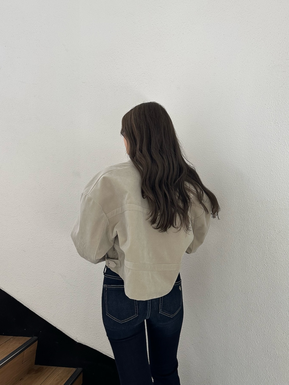 ブラック系のブーツ、ブルー系のデニムパンツ、ホワイト系のチューブトップを着用したレディースの秋コーディネートの5枚目の写真