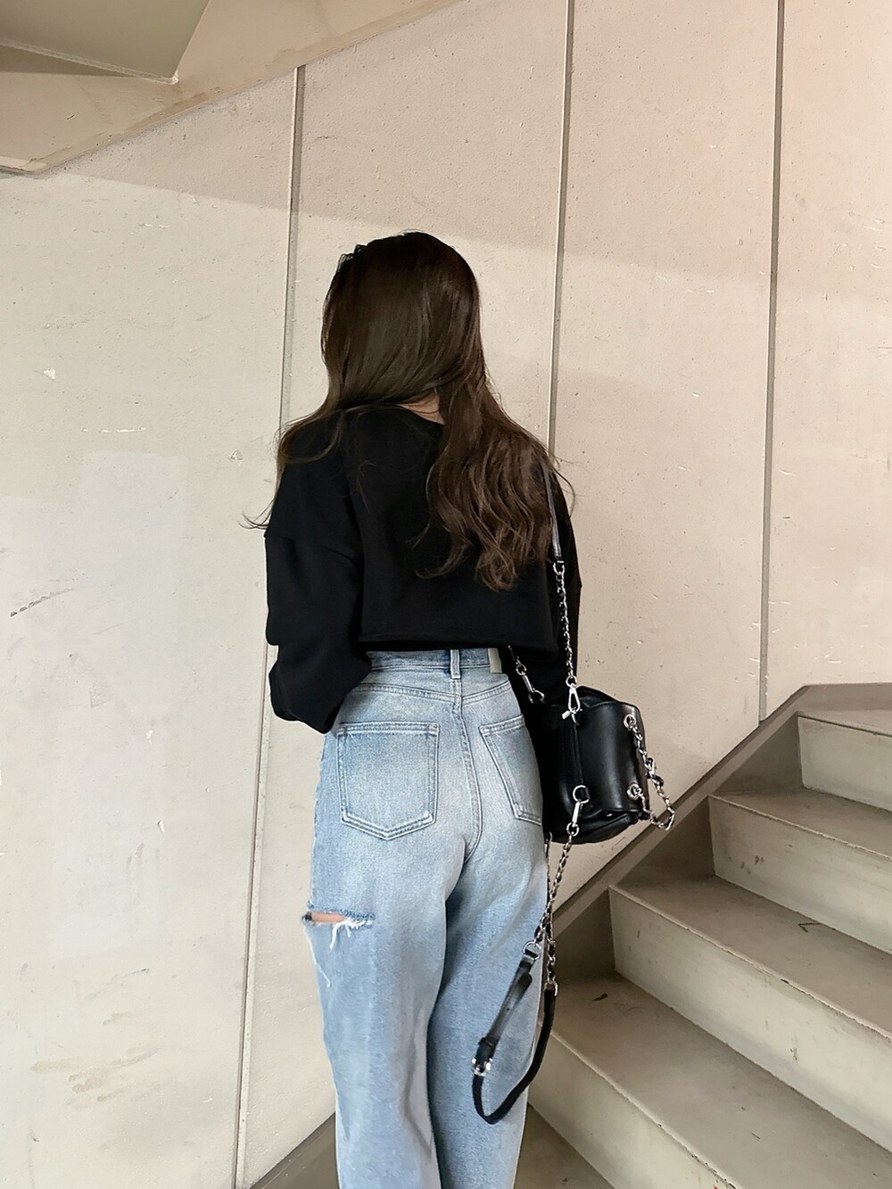 ブラック系のスウェット、ブルー系のデニムパンツ、ブラック系のバックパック/リュックを着用したレディースの冬コーディネートの8枚目の写真