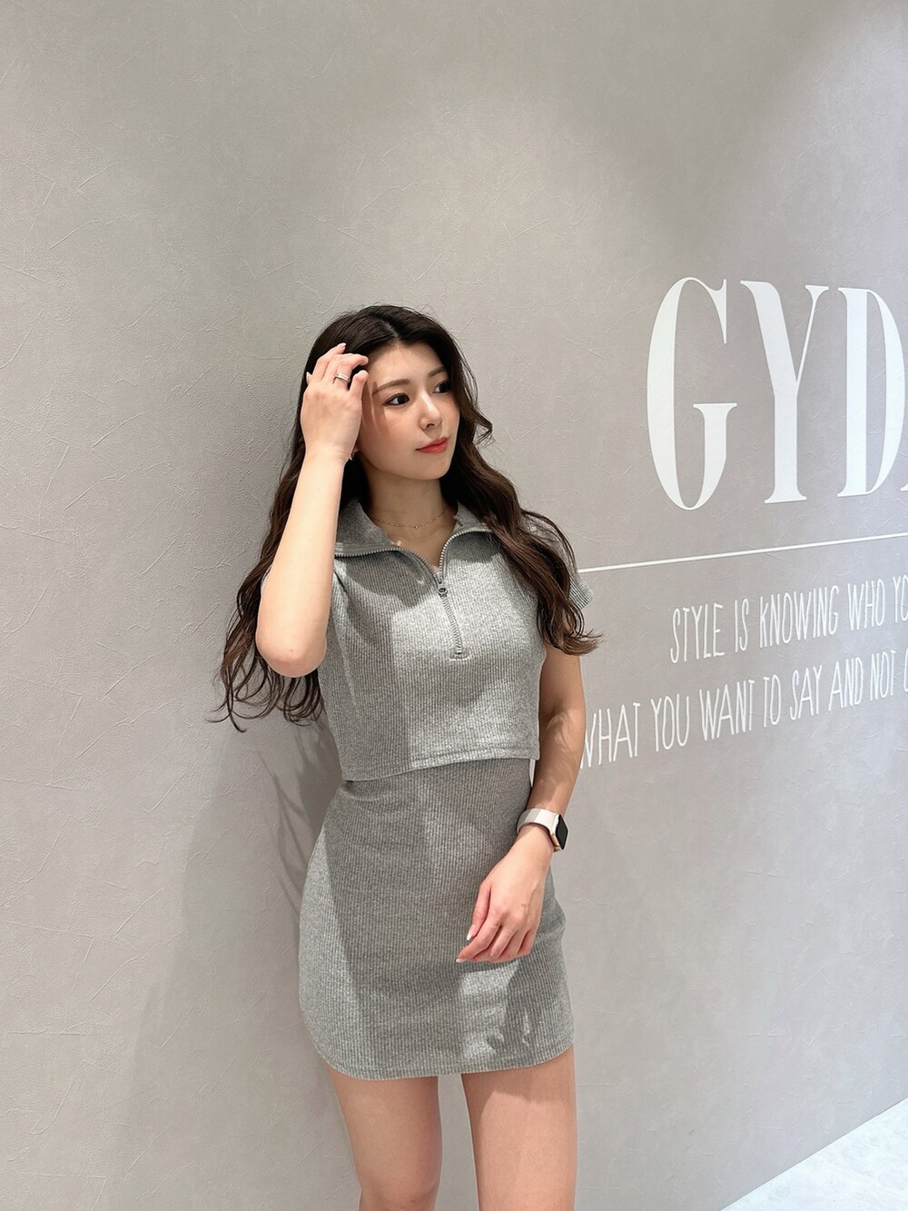 グレー系のワンピース、ブラック系のハンドバッグ、ブラック系のブーツを着用したレディースの春コーディネートの8枚目の写真