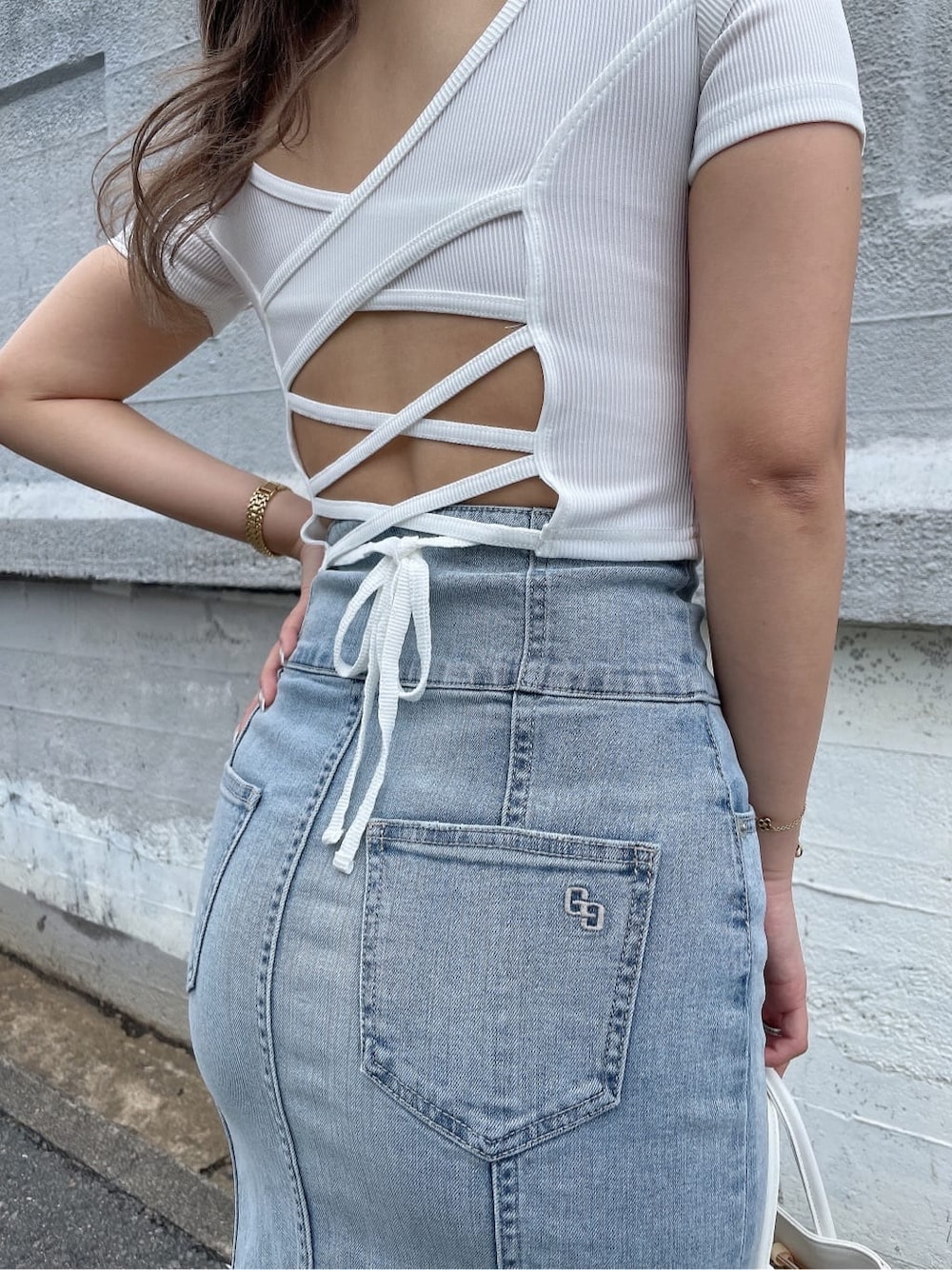 ホワイト系のハンドバッグ、ブルー系のデニムスカート、ホワイト系のTシャツ/カットソーを着用したレディースの夏コーディネートの8枚目の写真