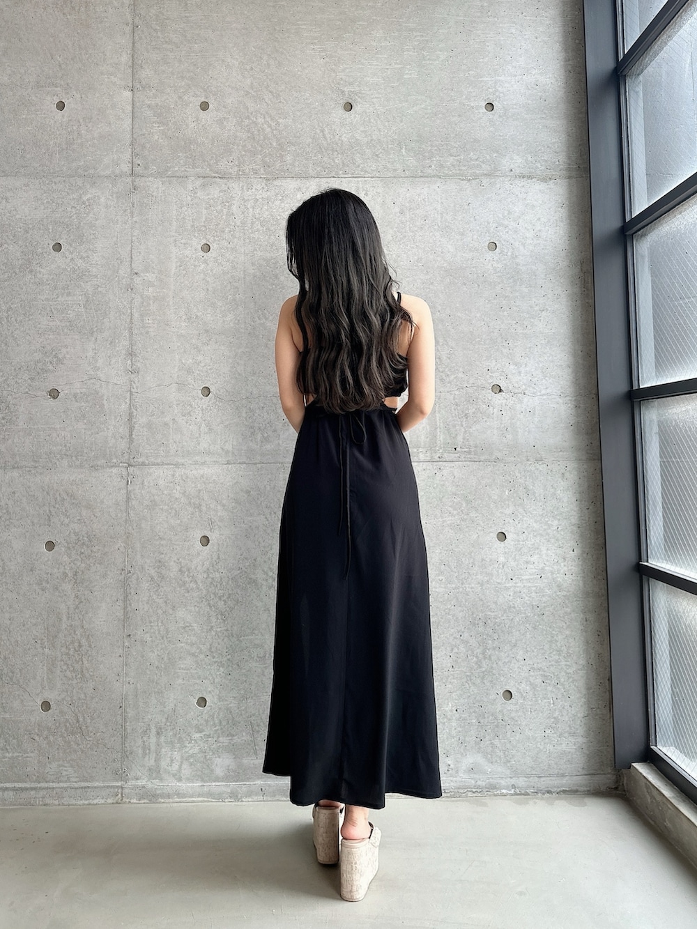 ホワイト系のサンダル、ブラック系のワンピース、ベージュ系のショルダーバッグを着用したレディースの夏コーディネートの5枚目の写真