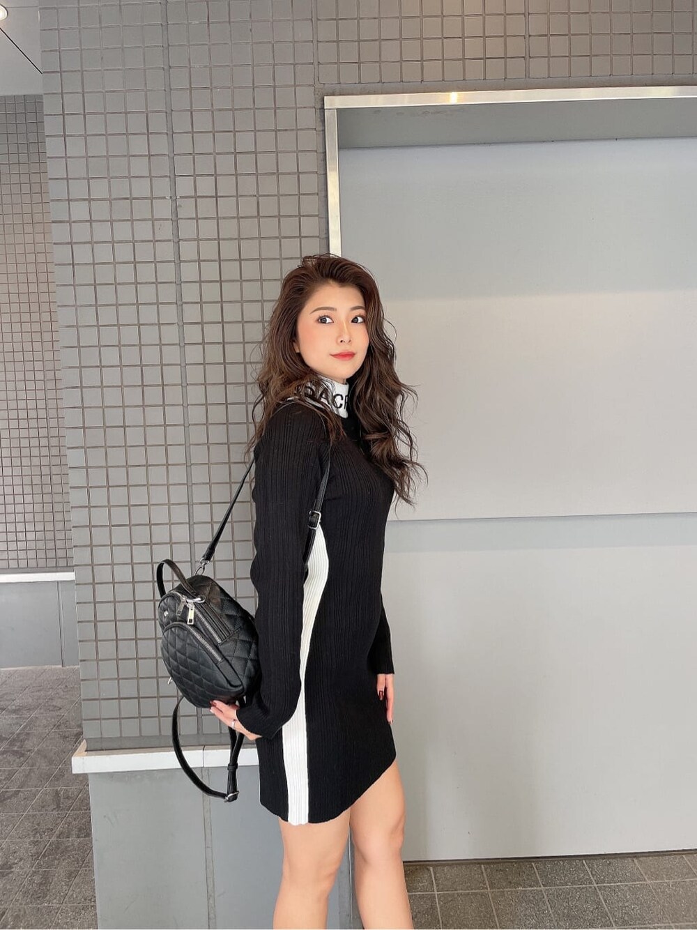 ブラック系のブーツ、ブラック系のバックパック/リュック、ブラック系のワンピースを着用したレディースの秋コーディネートの5枚目の写真