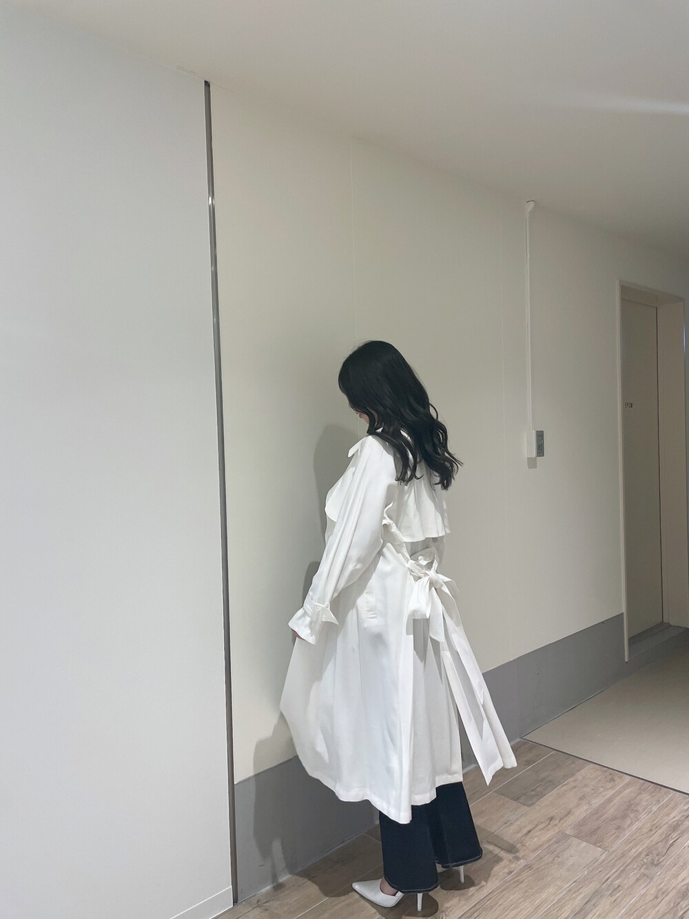 ブルー系のニット/セーター、ホワイト系のトレンチコート、ブルー系のデニムパンツを着用したレディースの春コーディネートの7枚目の写真