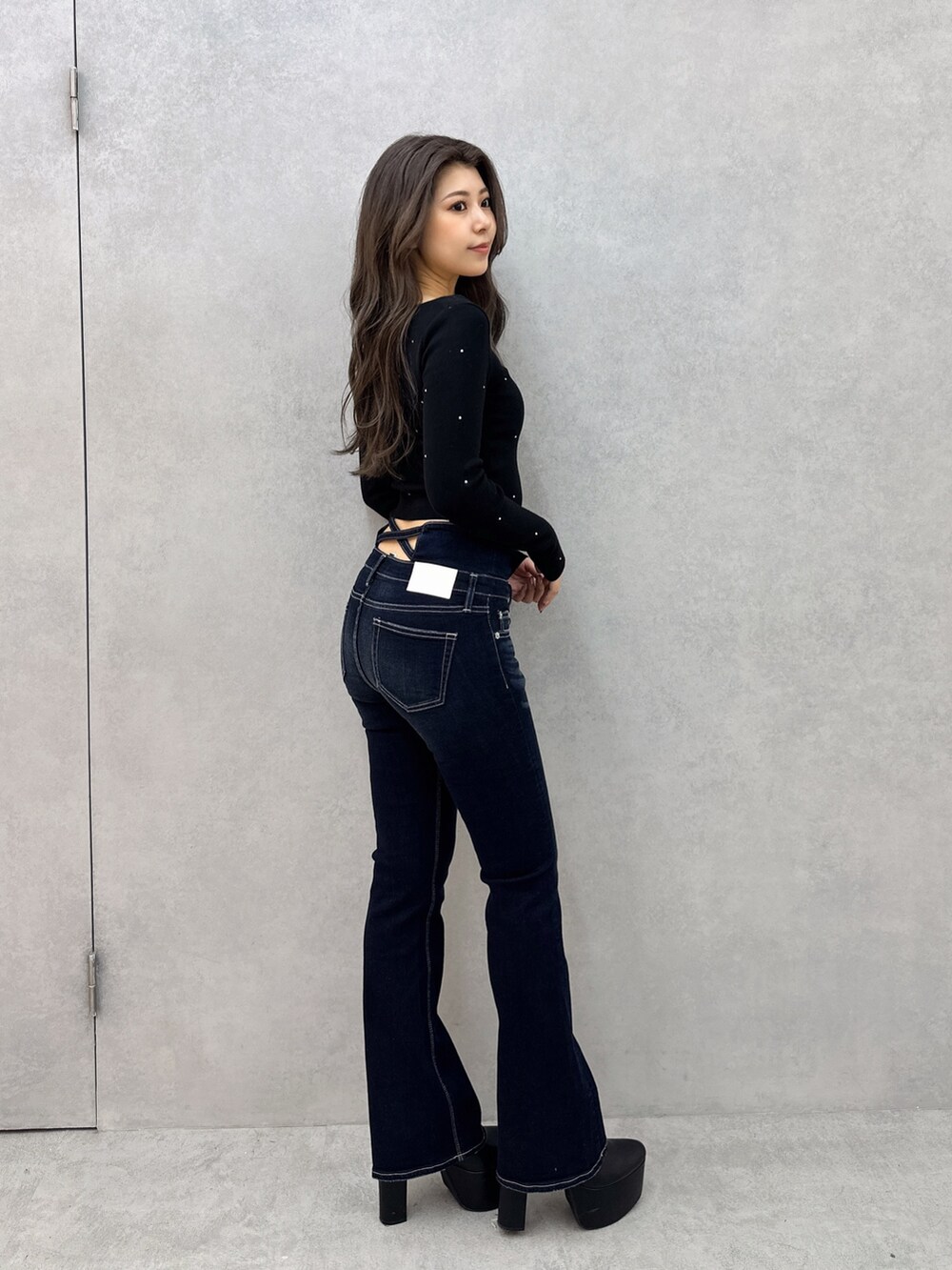 ブルー系のデニムパンツ、ブラック系のブーツ、ブラック系のニット/セーターを着用したレディースの冬コーディネートの2枚目の写真