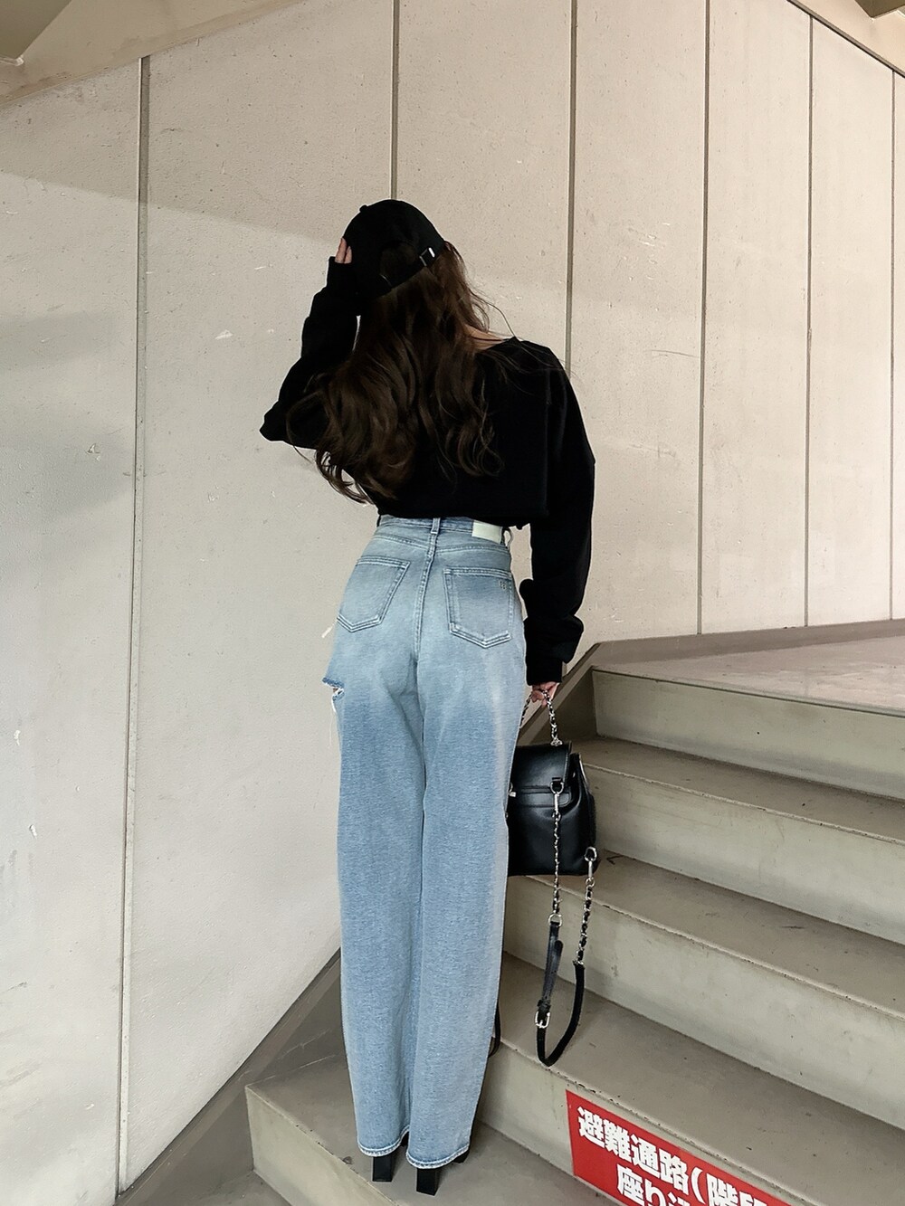 ブラック系のスウェット、ブルー系のデニムパンツ、ブラック系のバックパック/リュックを着用したレディースの冬コーディネートの4枚目の写真